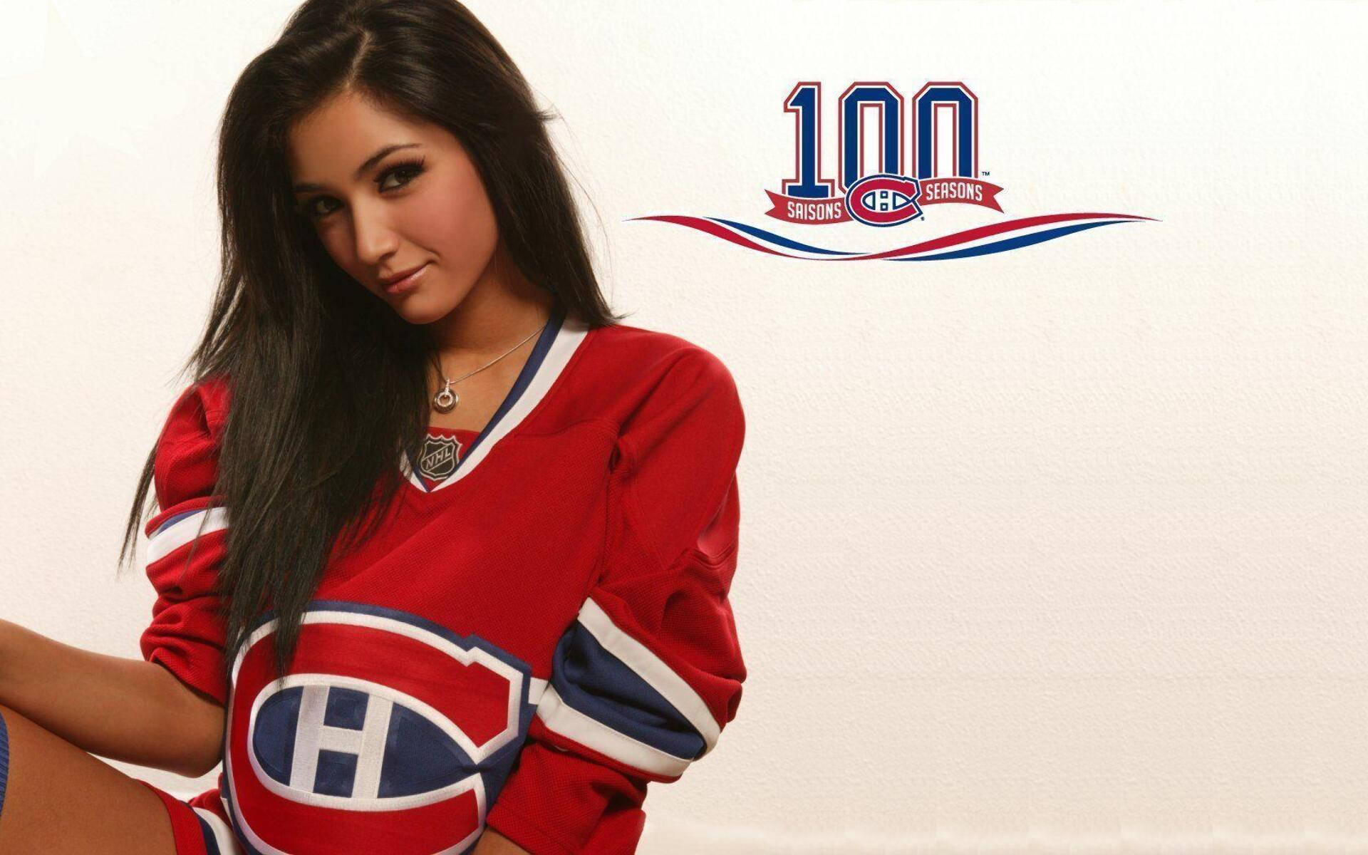 Canadiens 桌布 壁紙 — 一名身穿紅色蒙特婁加拿大人隊冰球球衣的女性，在白色背景前擺姿勢，背景有球隊的100賽季標誌。