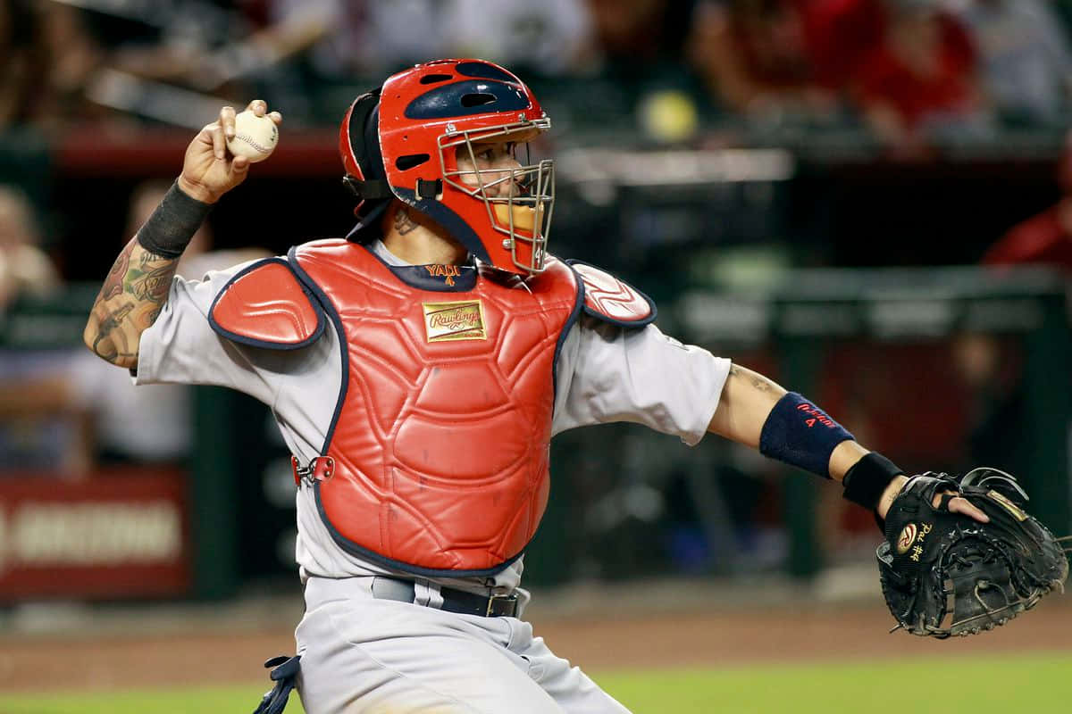 Yadier Molina 桌布 壁紙 — 一名身穿紅色裝備的棒球捕手在球場燈光下的夜間比賽中，專注地投球。
