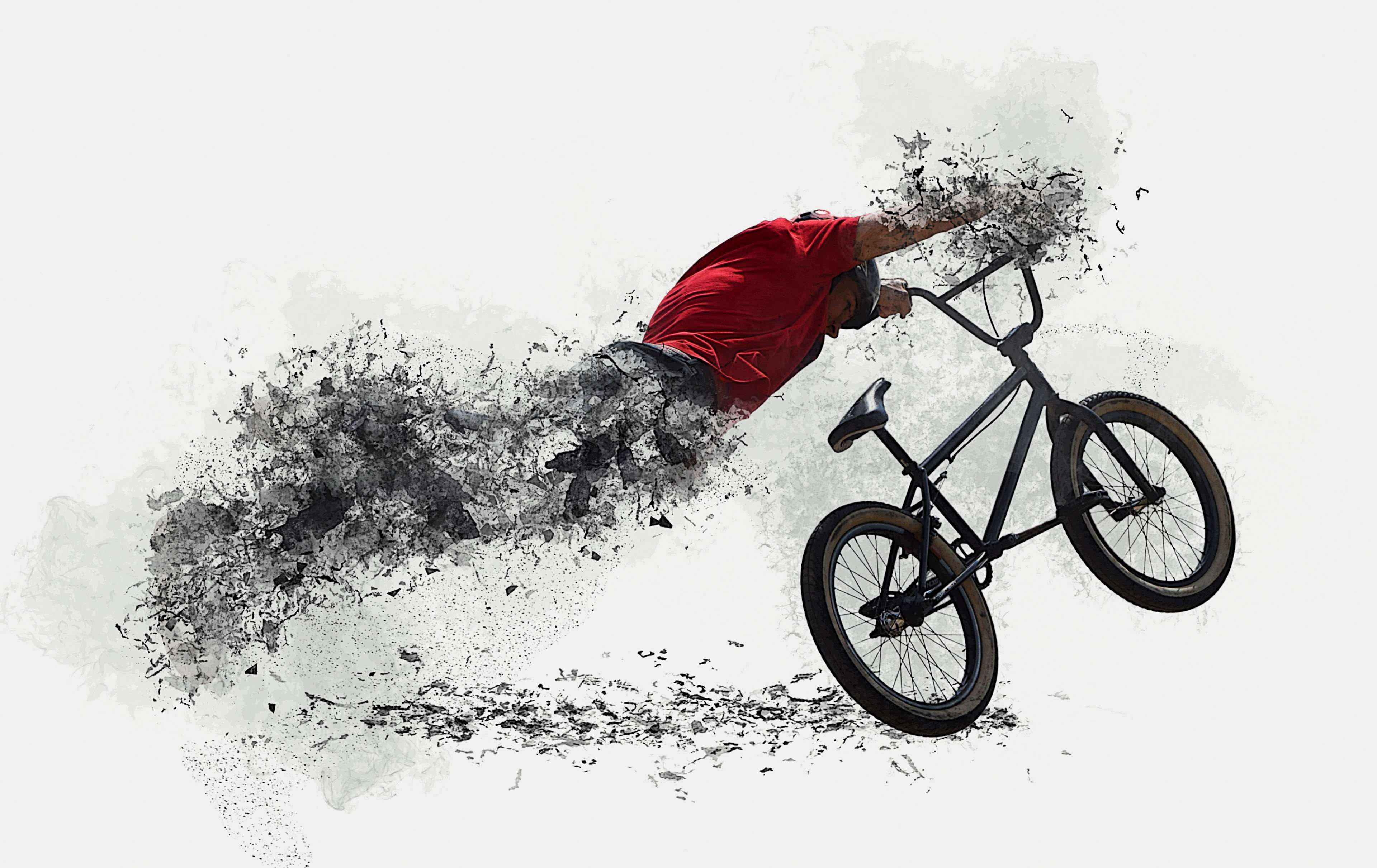 Bicycle 桌布 壁紙 — 一名身穿紅色襯衫的BMX車手在半空中表演特技，身體和單車碎裂成動態的黑色墨水飛濺，背景為純白色。