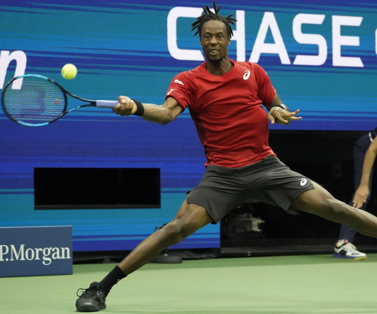 Tennis 桌布 壁紙 — 一名身穿紅色襯衫的男性網球選手在綠色球場上撲身用藍色球拍擊打黃色球。