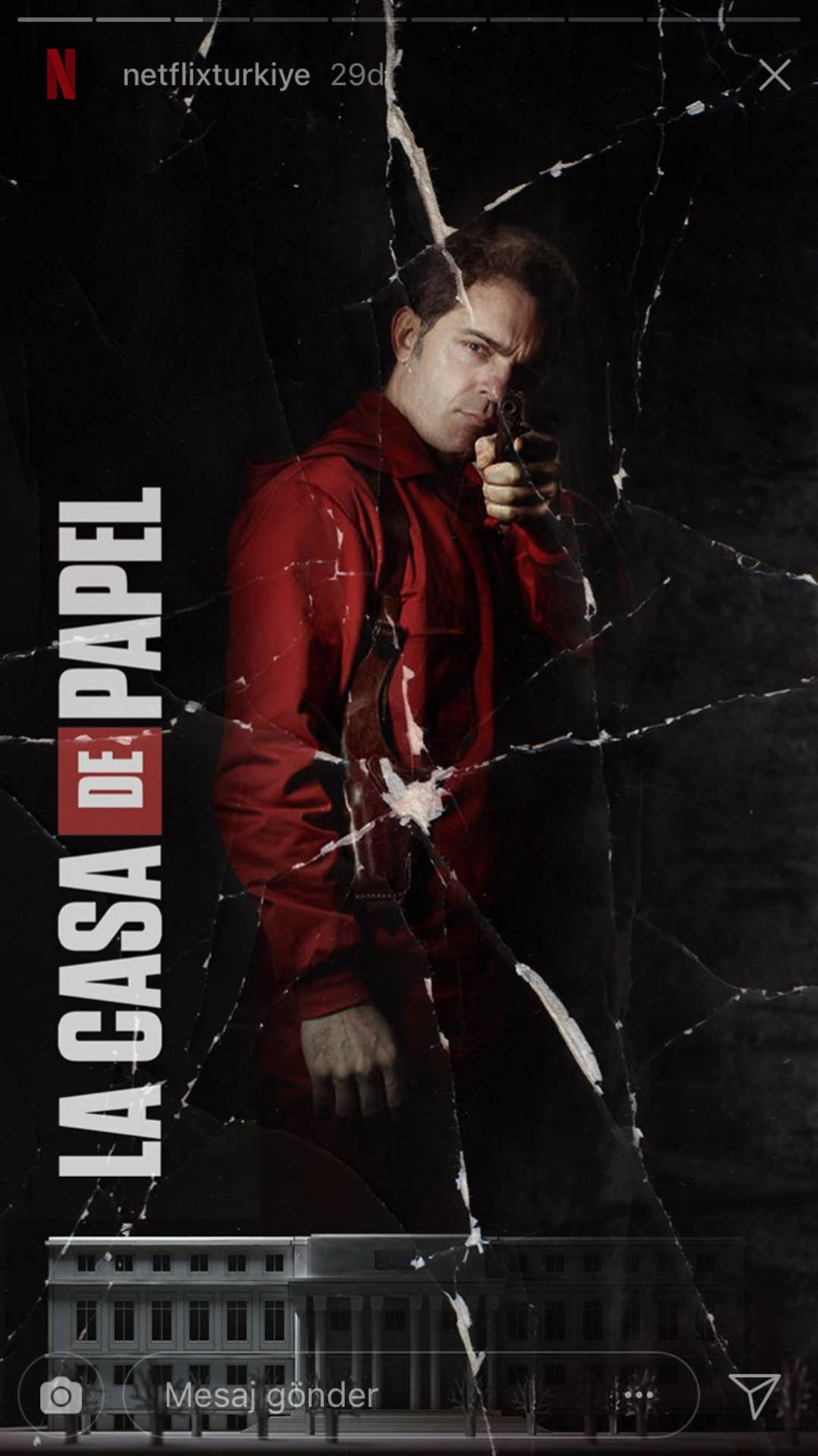 Berlin Money Heist 桌布 壁紙 — 一名身穿紅色連身衣的男子透過裂紋玻璃效果持槍，背景為深色，下方有建築物。