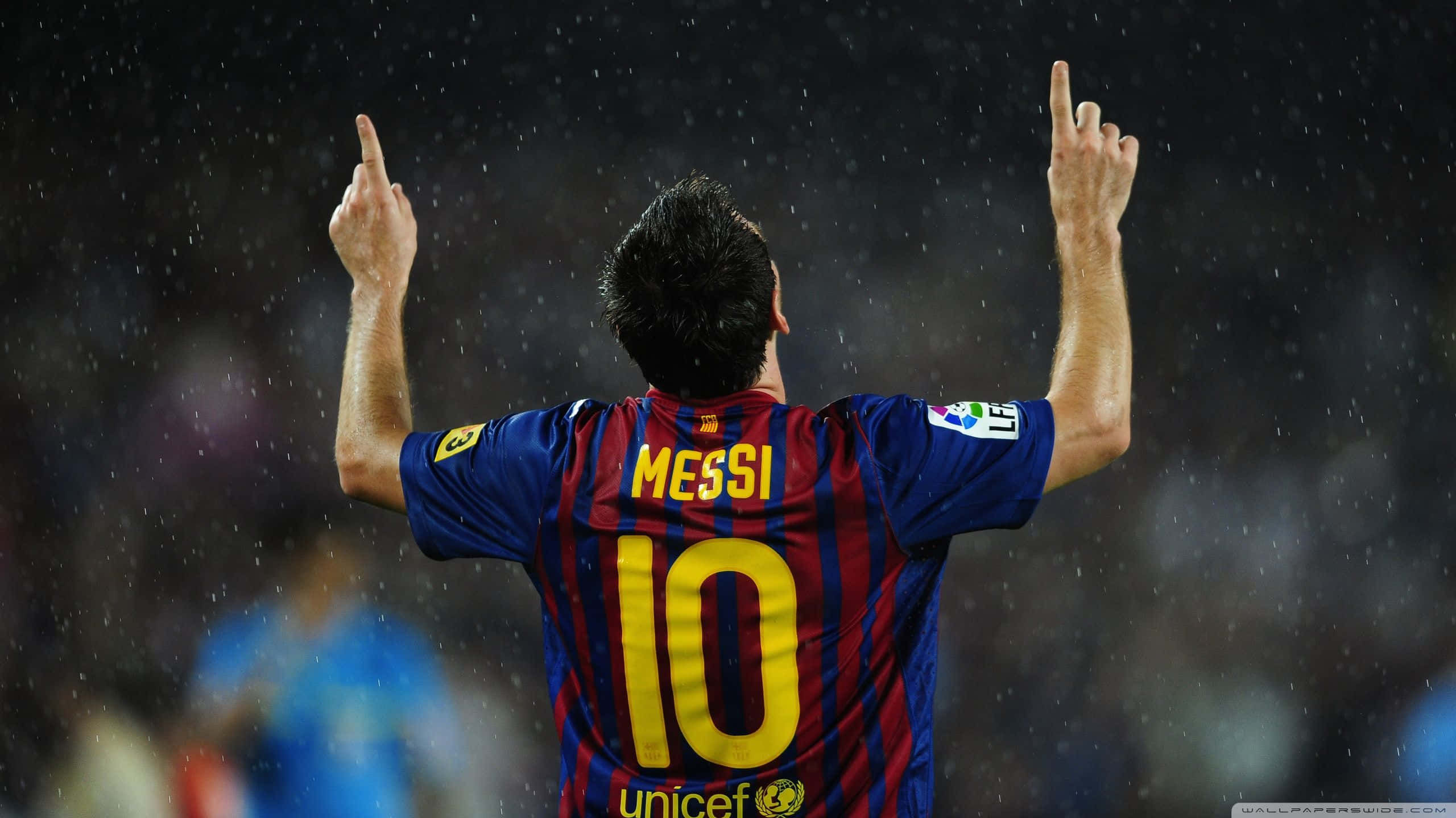 Lionel Messi Cool 桌布 壁紙 — 一名身穿紅藍條紋球衣、背號10及名字梅西的足球員在雨夜比賽中高舉雙手慶祝。