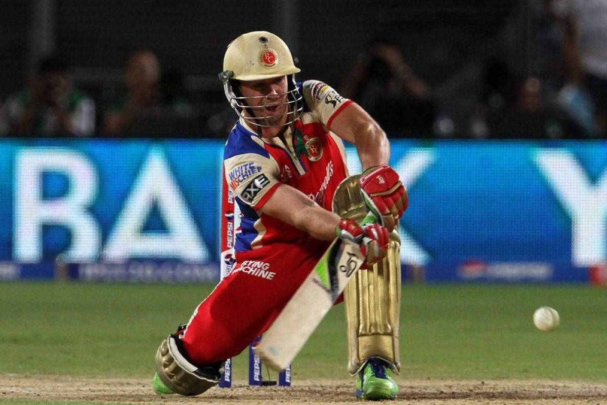 Ab De Villiers 桌布 壁紙 — 一名身穿紅藍球衣的板球運動員在夜間比賽中，在球場燈光下強力揮棒。