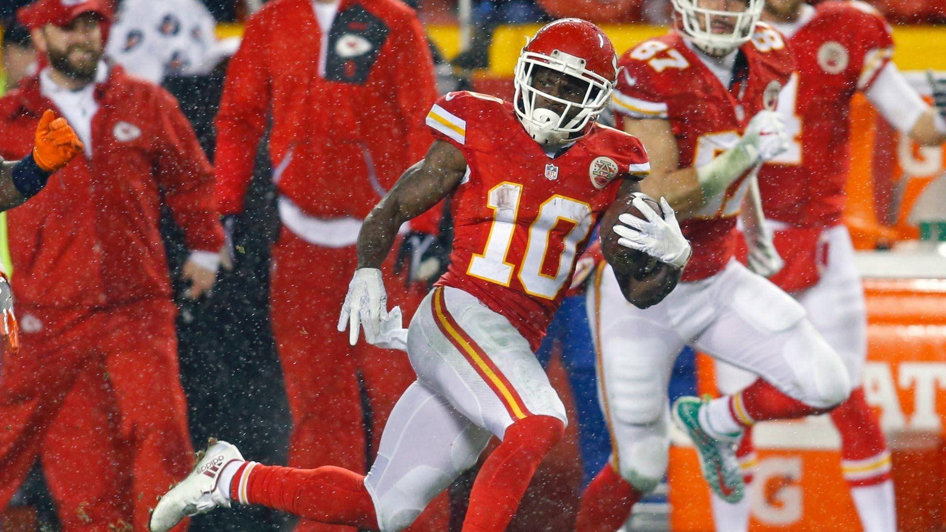 Tyreek Hill 桌布 壁紙 — 一名身穿紅金色球衣的堪薩斯城酋長隊美式足球員在比賽期間於飄雪中持球奔跑。