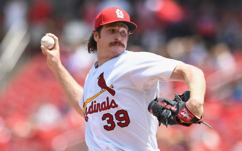 St Louis Cardinals 桌布 壁紙 — 一名身穿紅雀隊球衣的棒球投手，在模糊的球場背景下專注地投球。