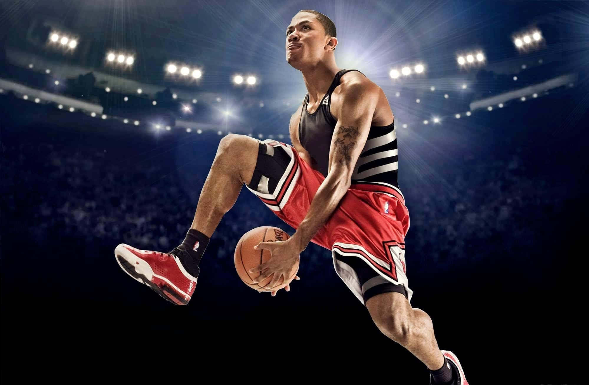 derrick rose 桌布 壁紙 — 一名身穿紅黑球衣的籃球運動員在明亮的場館燈光下，動態地躍起並持球。
