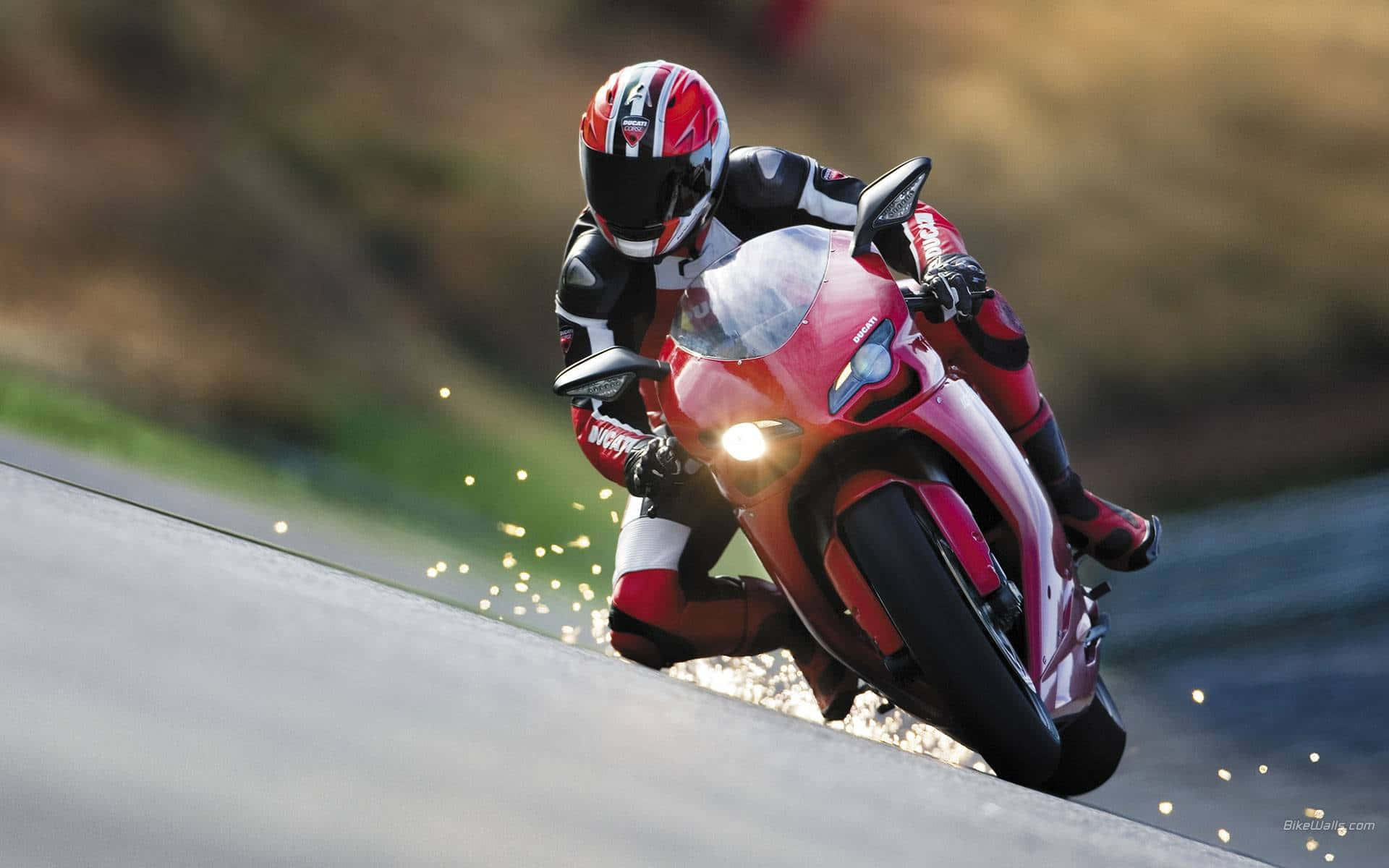 biker 桌布 壁紙 — 一名身穿紅黑裝備的騎士在濕滑路面上駕駛紅色運動機車，傾斜入急彎，擦出火花。