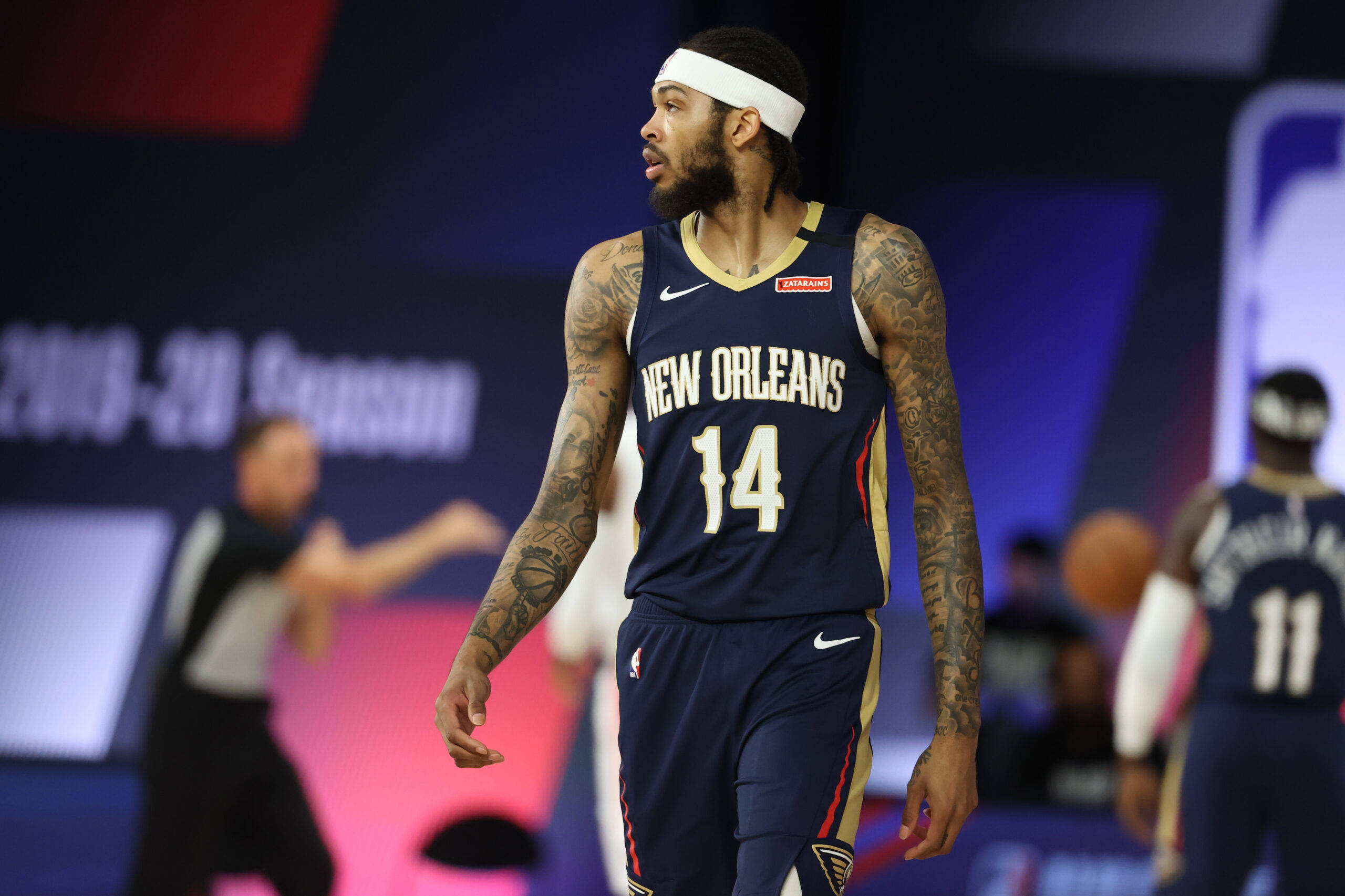NBA 桌布 壁紙 — 一名身穿紐奧良球衣、帶有刺青和頭帶的籃球運動員在比賽期間在球場上行走。