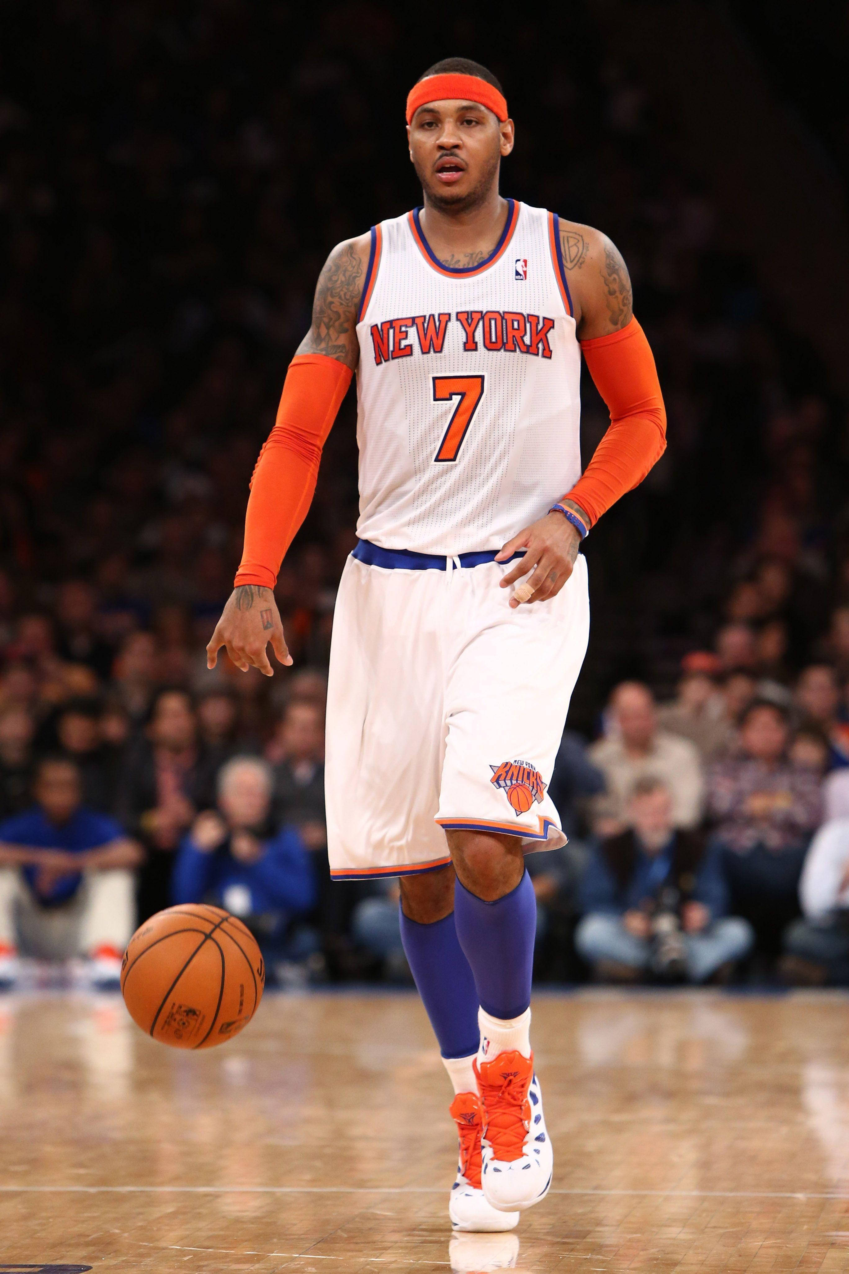 Carmelo 桌布 壁紙 — 一名身穿紐約尼克隊球衣的籃球運動員在硬木球場上運球，背景是模糊的人群。