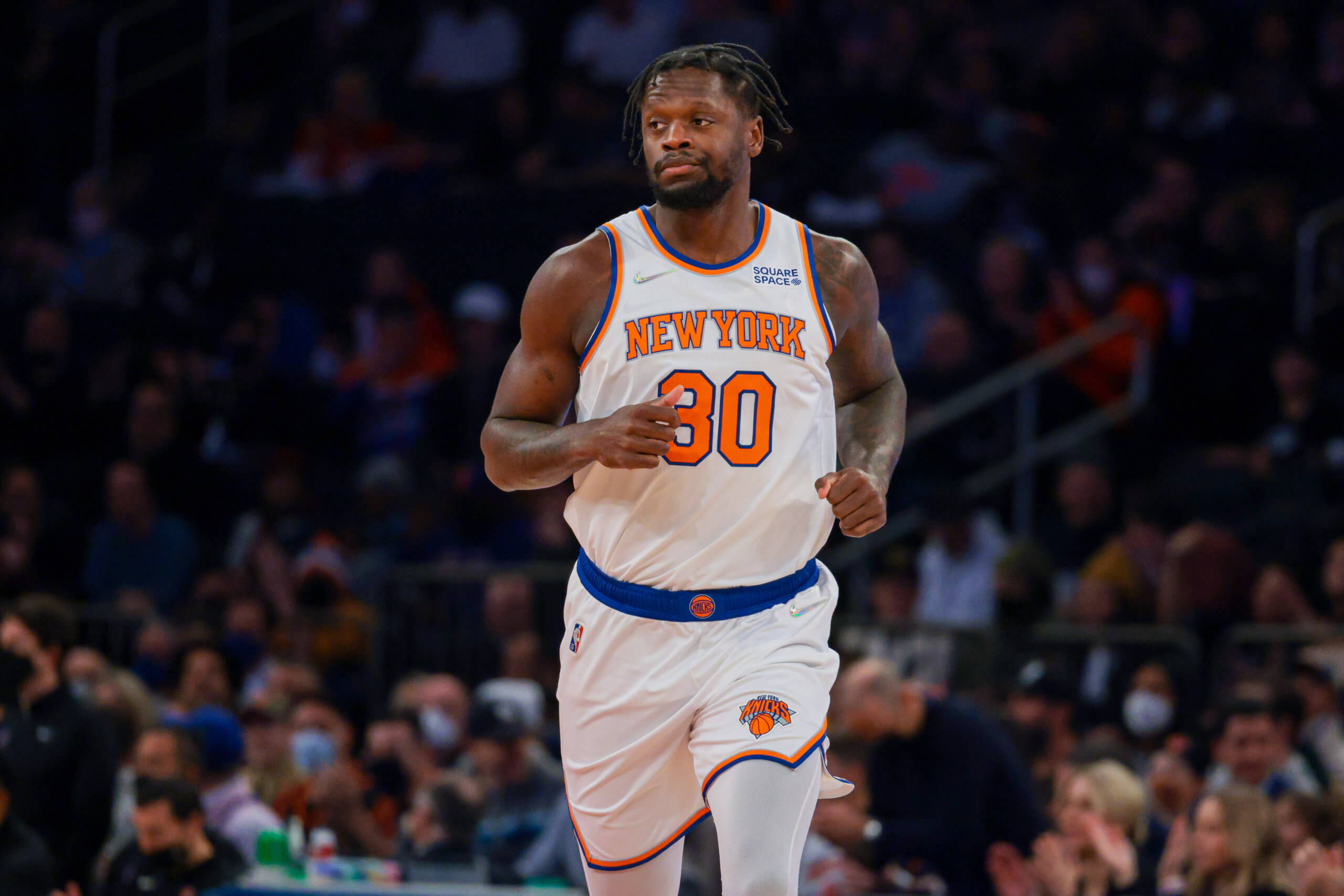 NBA 桌布 壁紙 — 一名身穿紐約尼克隊球衣的籃球運動員在球場上奔跑，背景是模糊的人群。