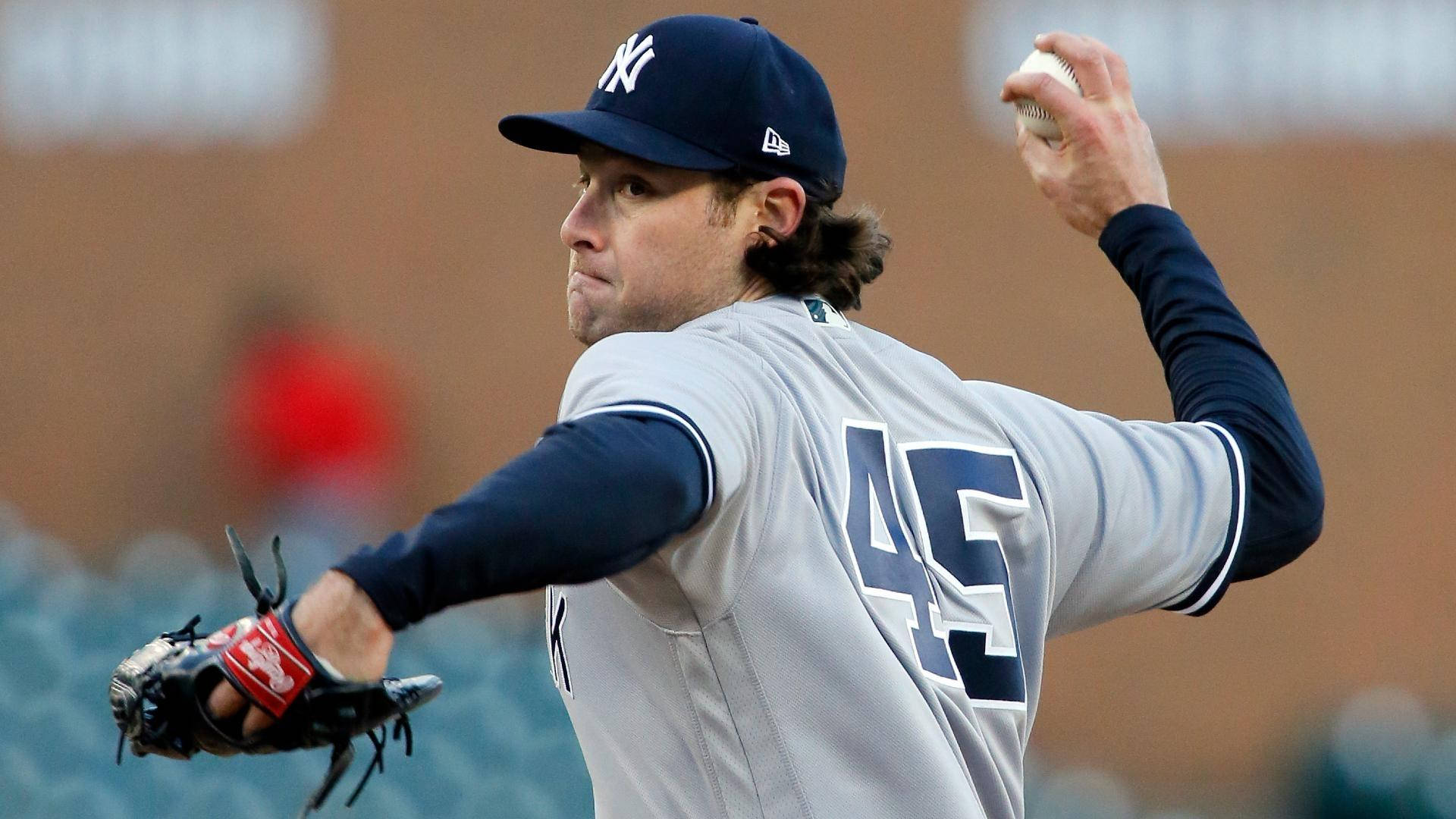 Gerrit Cole 桌布 壁紙 — 一名身穿紐約洋基隊球衣的棒球投手，在日間比賽中揮臂準備投球。