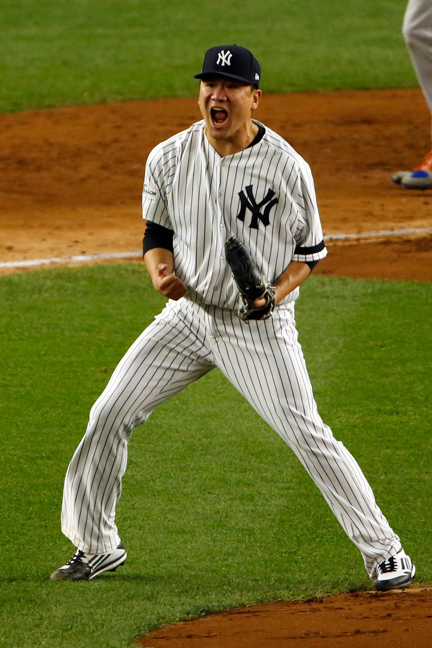 masahiro tanaka 桌布 壁紙 — 一名身穿紐約洋基隊球衣的棒球運動員在燈火通明的球場上進行夜間比賽時激情吶喊。