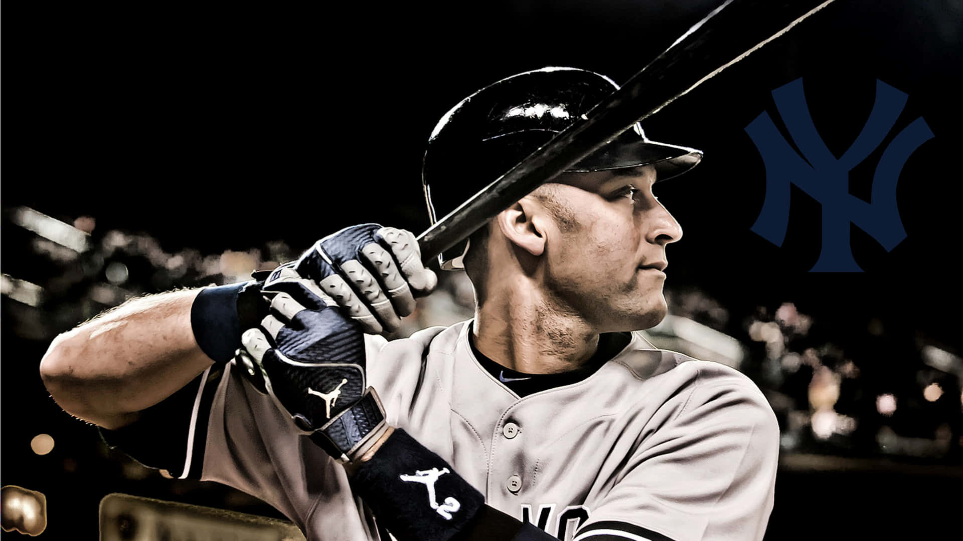 Derek Jeter 桌布 壁紙 — 一名身穿紐約洋基隊球衣的棒球選手，在球場燈光下以專注的打擊姿勢握著球棒。