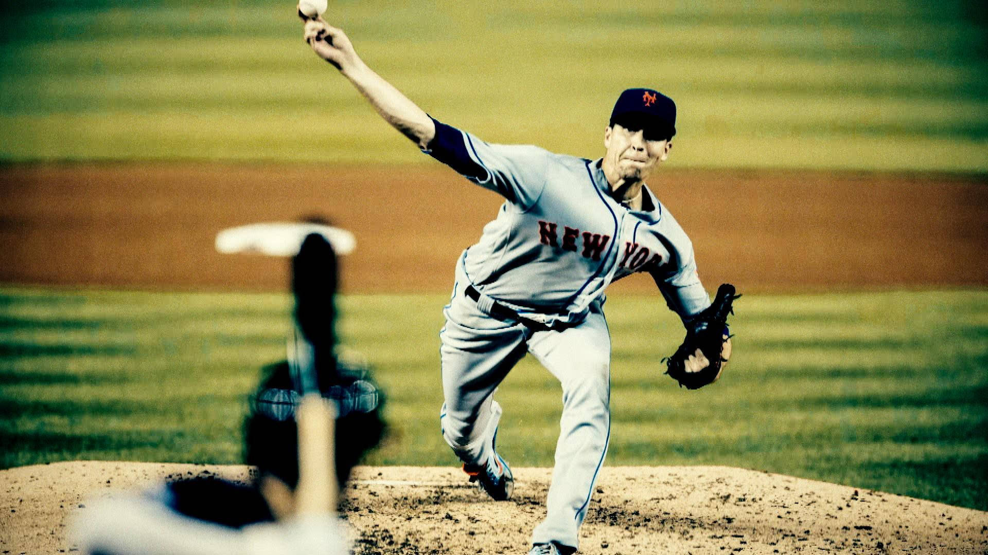 Degrom 桌布 壁紙 — 一名身穿紐約球衣的棒球投手在陽光明媚的球場上投球，打者在前景模糊。