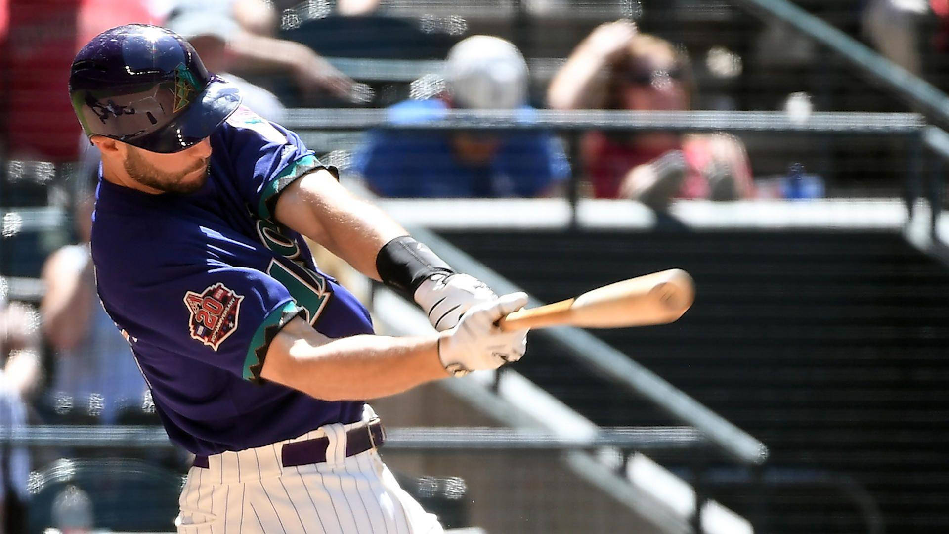 Paul Goldschmidt 桌布 壁紙 — 一名身穿紫色球衣的棒球選手在日間比賽中專注地揮動木製球棒。