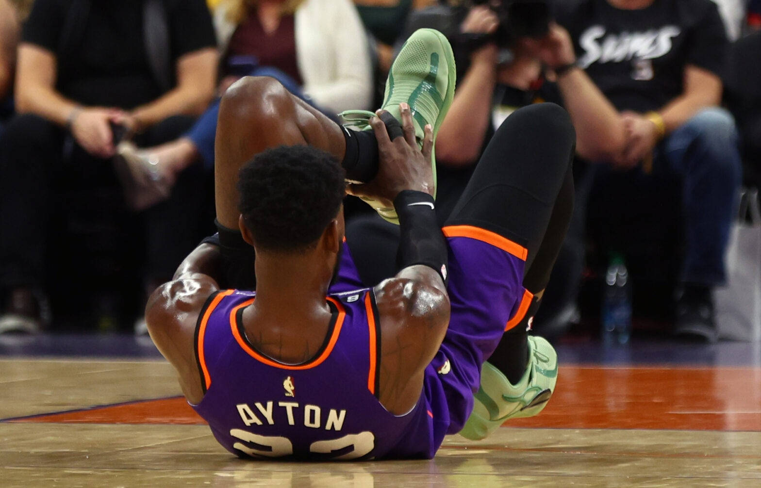 NBA 桌布 壁紙 — 一名身穿紫色球衣的籃球運動員在比賽中坐在球場上，明顯痛苦地抱著腳。