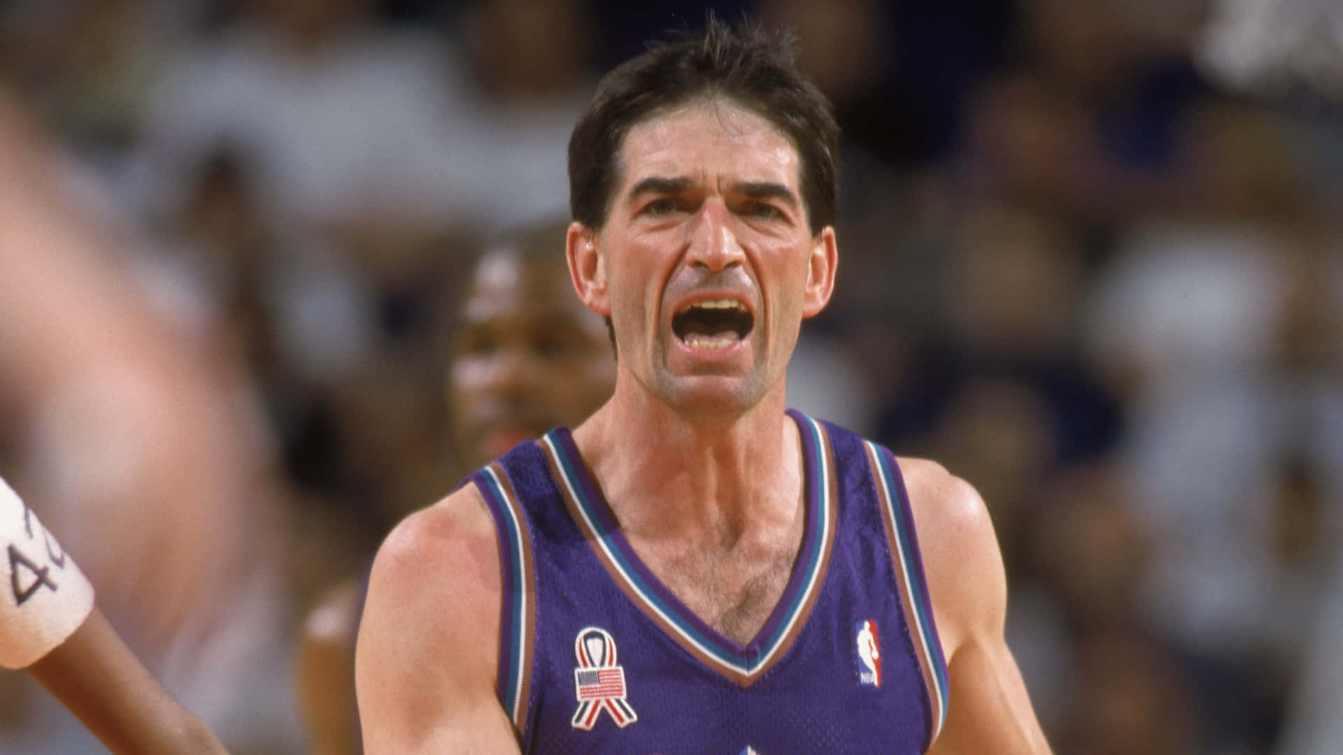 NBA 桌布 壁紙 — 一名身穿紫色球衣的籃球運動員在比賽中激烈尖叫，身後是模糊的人群。