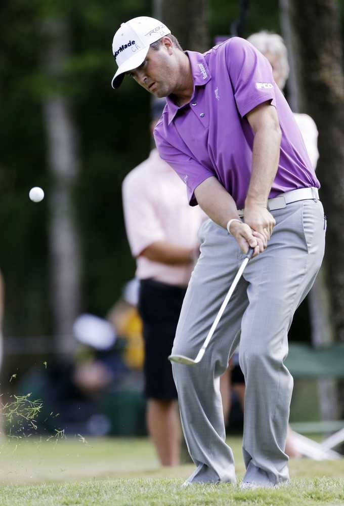 Ryan Palmer 桌布 壁紙 — 一名身穿紫色襯衫的高爾夫球手在陽光明媚的比賽日，專注地揮桿，草從發球檯飛起。