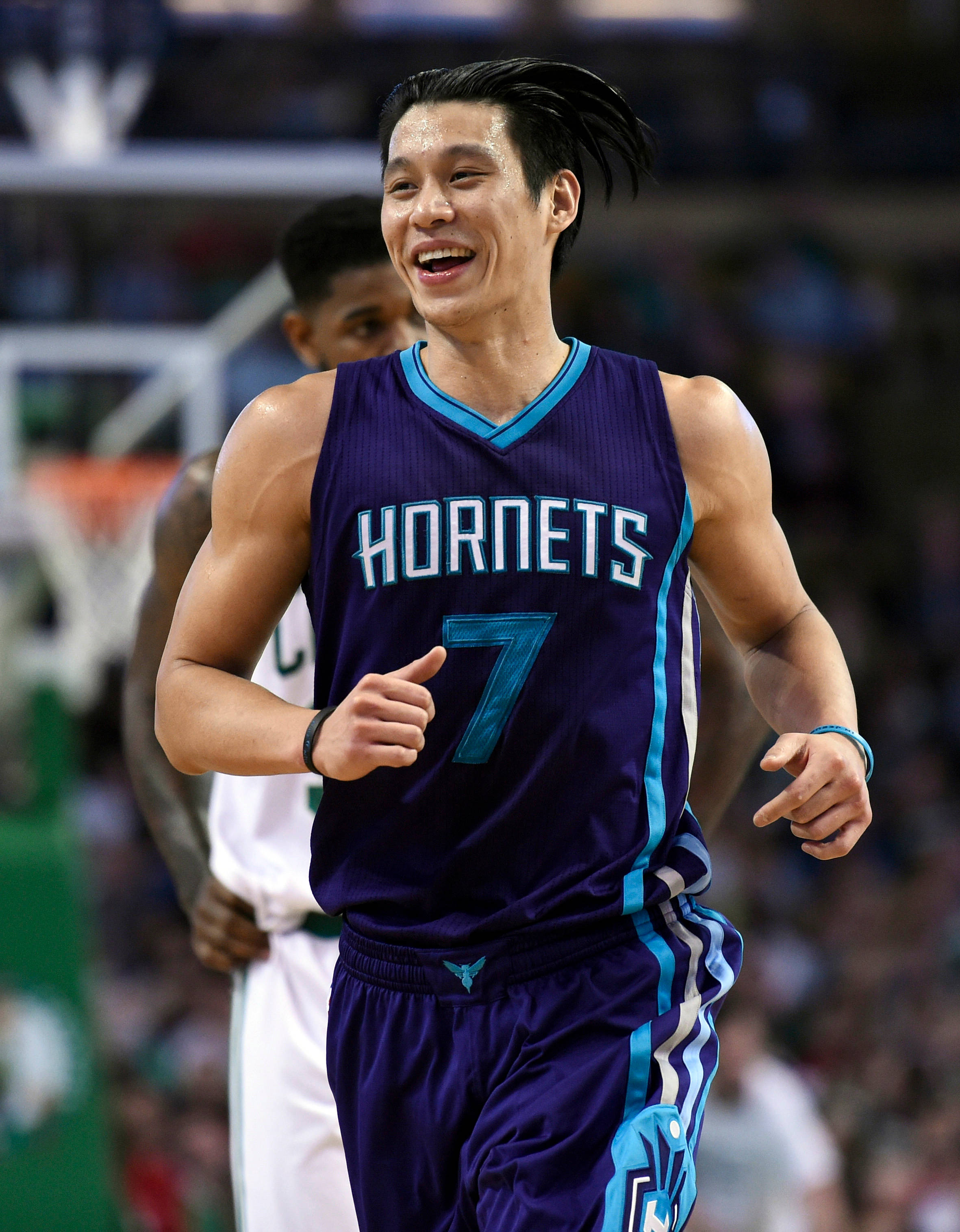 Lin 桌布 壁紙 — 一名身穿紫色黃蜂隊球衣的籃球運動員在球場上奔跑，身後是模糊的人群，露出燦爛的笑容。