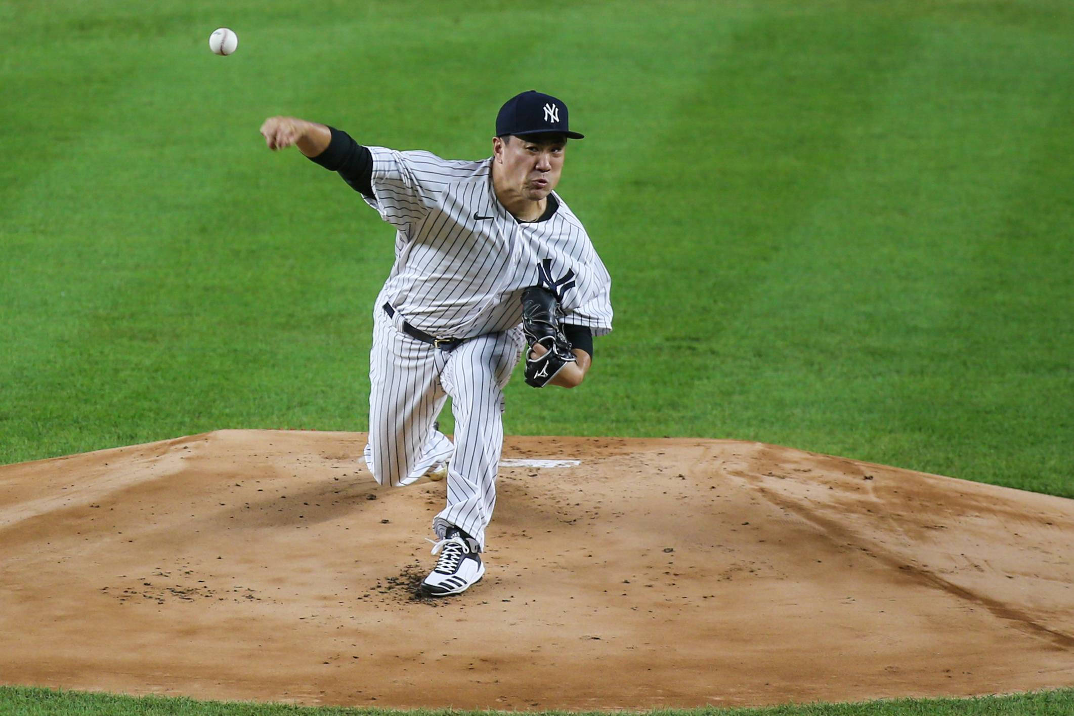 masahiro tanaka 桌布 壁紙 — 一名身穿細條紋球衣的棒球投手在土丘上投球，背景是綠色草地。