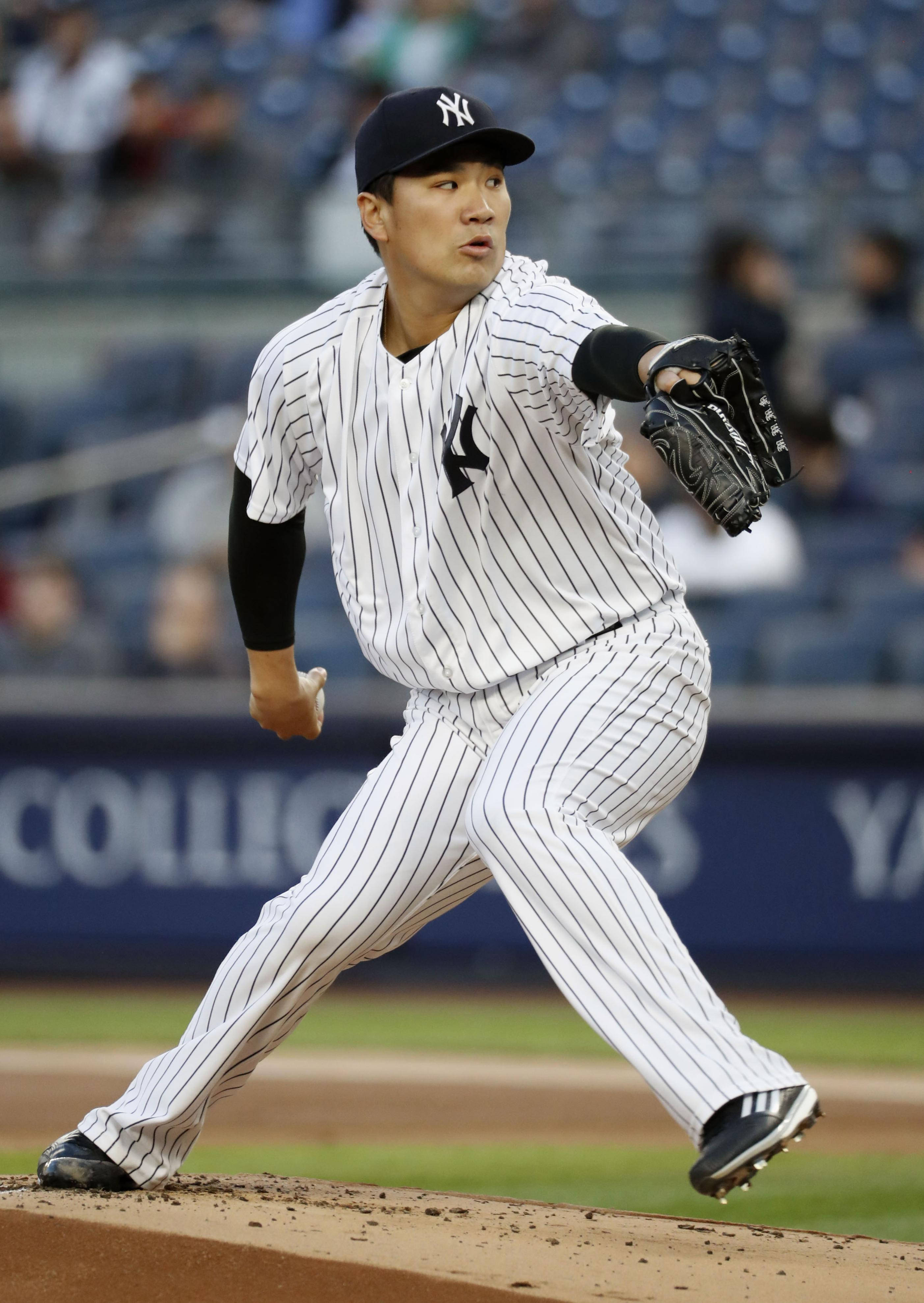 masahiro tanaka 桌布 壁紙 — 一名身穿細條紋球衣的棒球投手在泥土投手丘上投球，背景的體育場座位模糊不清。