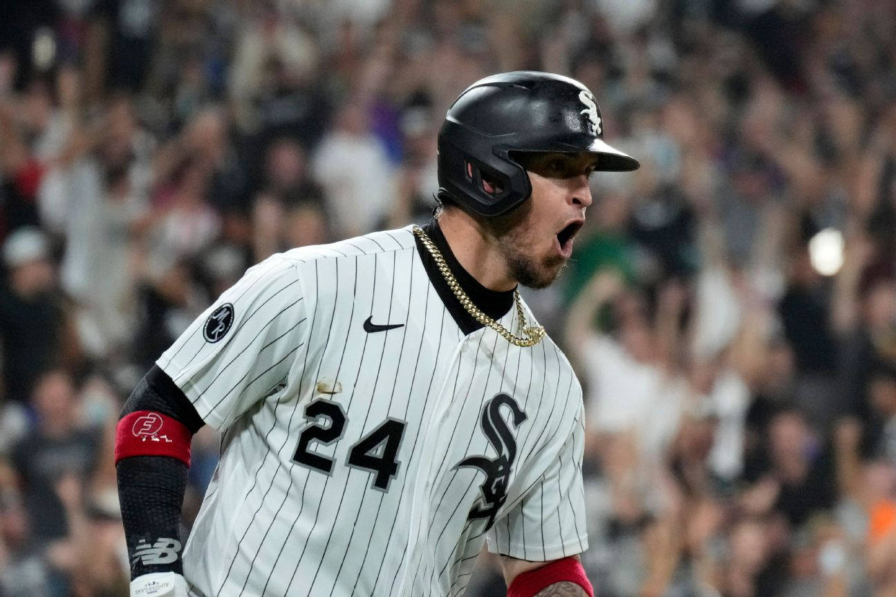 Chicago White Sox 桌布 壁紙 — 一名身穿細條紋球衣的棒球運動員在夜間球場燈光下，身後有歡呼的人群，發出勝利的咆哮。