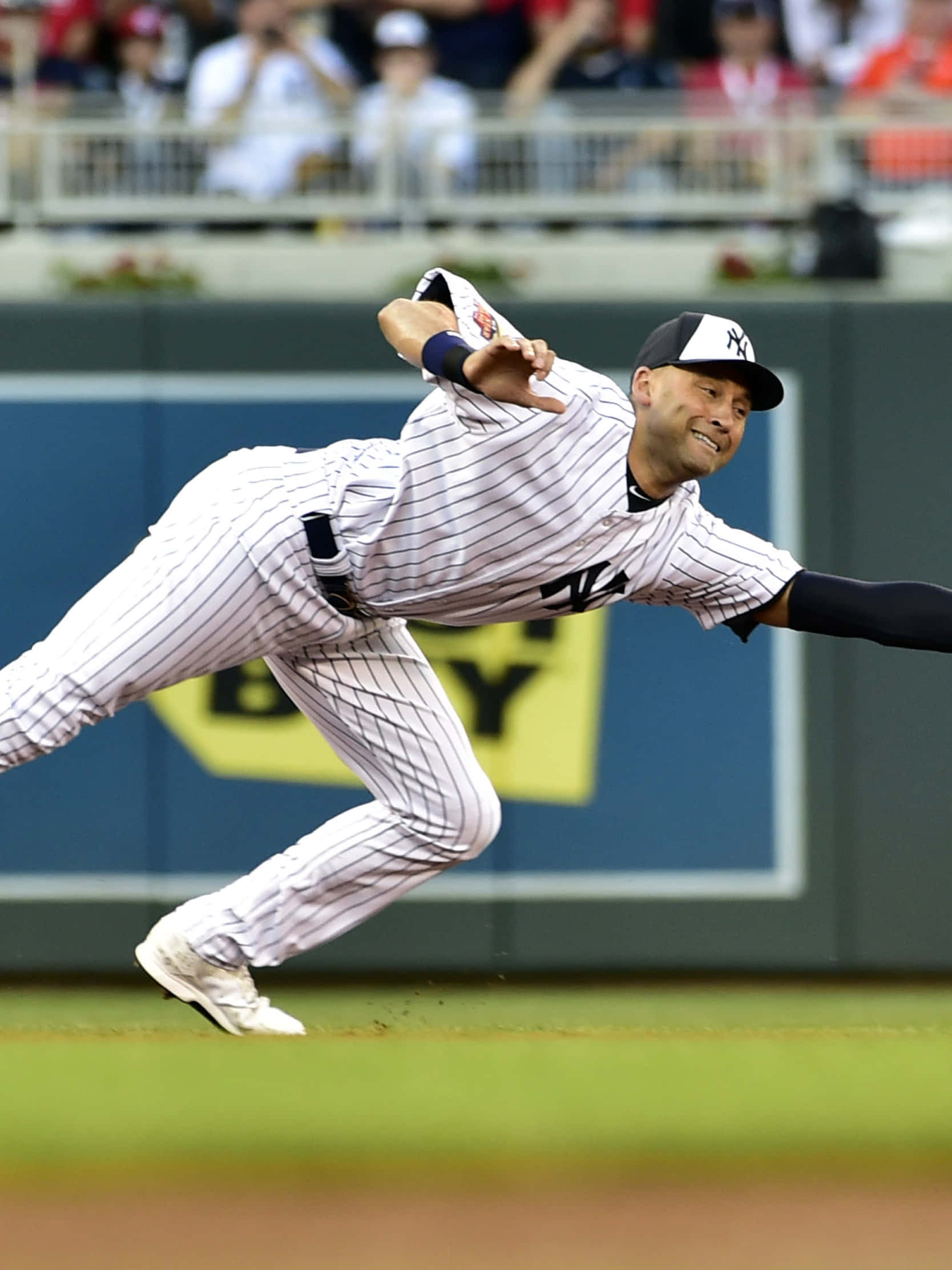 Derek Jeter 桌布 壁紙 — 一名身穿細條紋球衣的棒球選手向前飛撲，伸出手套在綠色場地上接球。