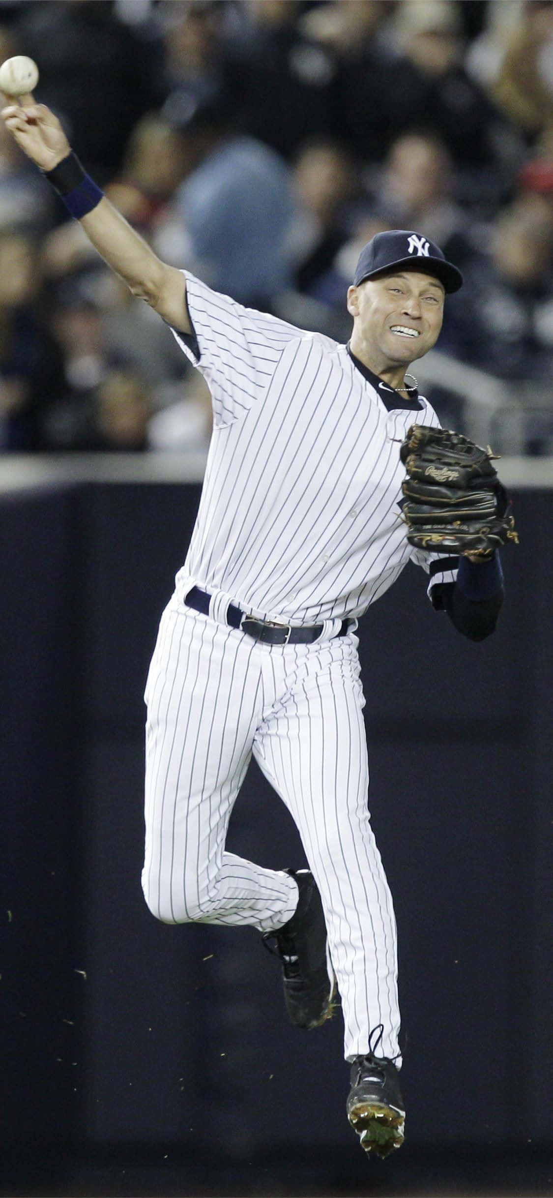 Derek Jeter 桌布 壁紙 — 一名身穿細條紋球衣的棒球選手在夜間比賽中，全神貫注地跳起投球。