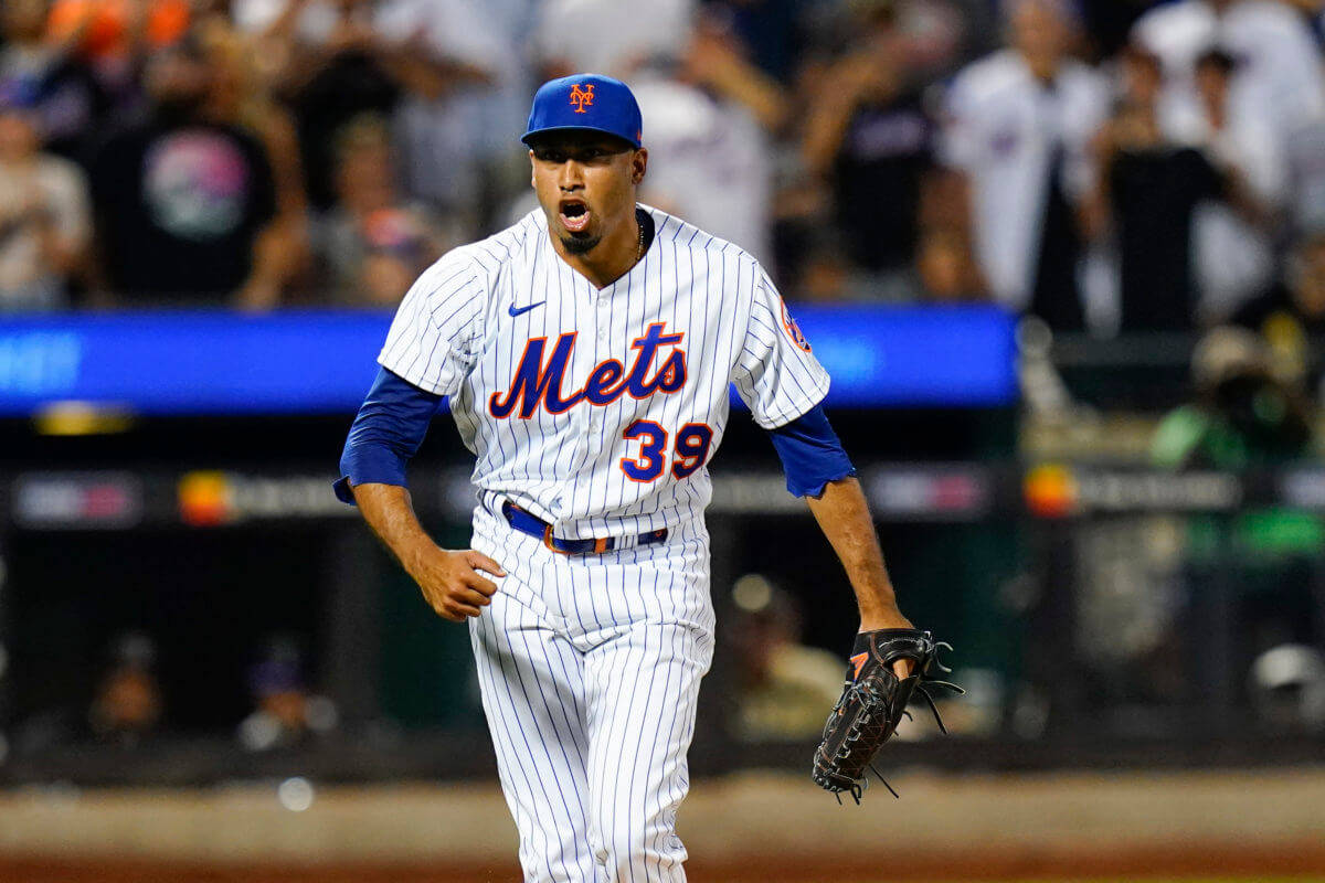 MLB 桌布 壁紙 — 一名身穿細條紋球衣的紐約大都會棒球選手在夜間比賽中，在球場燈光下張開嘴巴跑過球場。