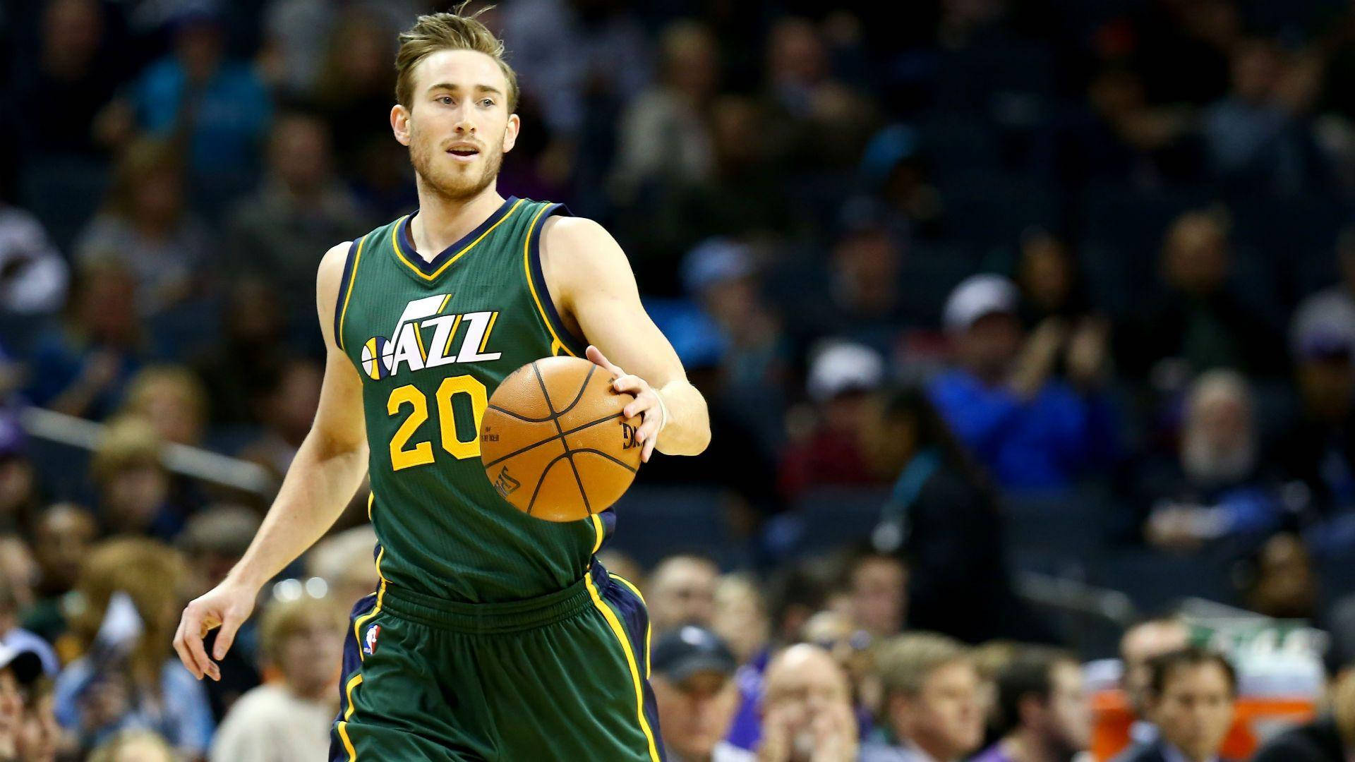 gordon hayward 桌布 壁紙 — 一名身穿綠色Jazz球衣的籃球運動員在場館燈光下進行激烈比賽時運球。