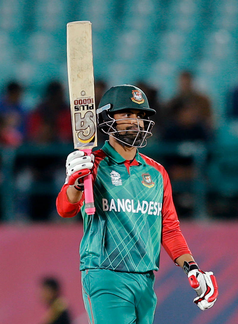 Bangladesh Cricket 桌布 壁紙 — 一名身穿綠色和紅色球衣的孟加拉國板球運動員在夜間的體育場上高舉球棒，慶祝勝利。