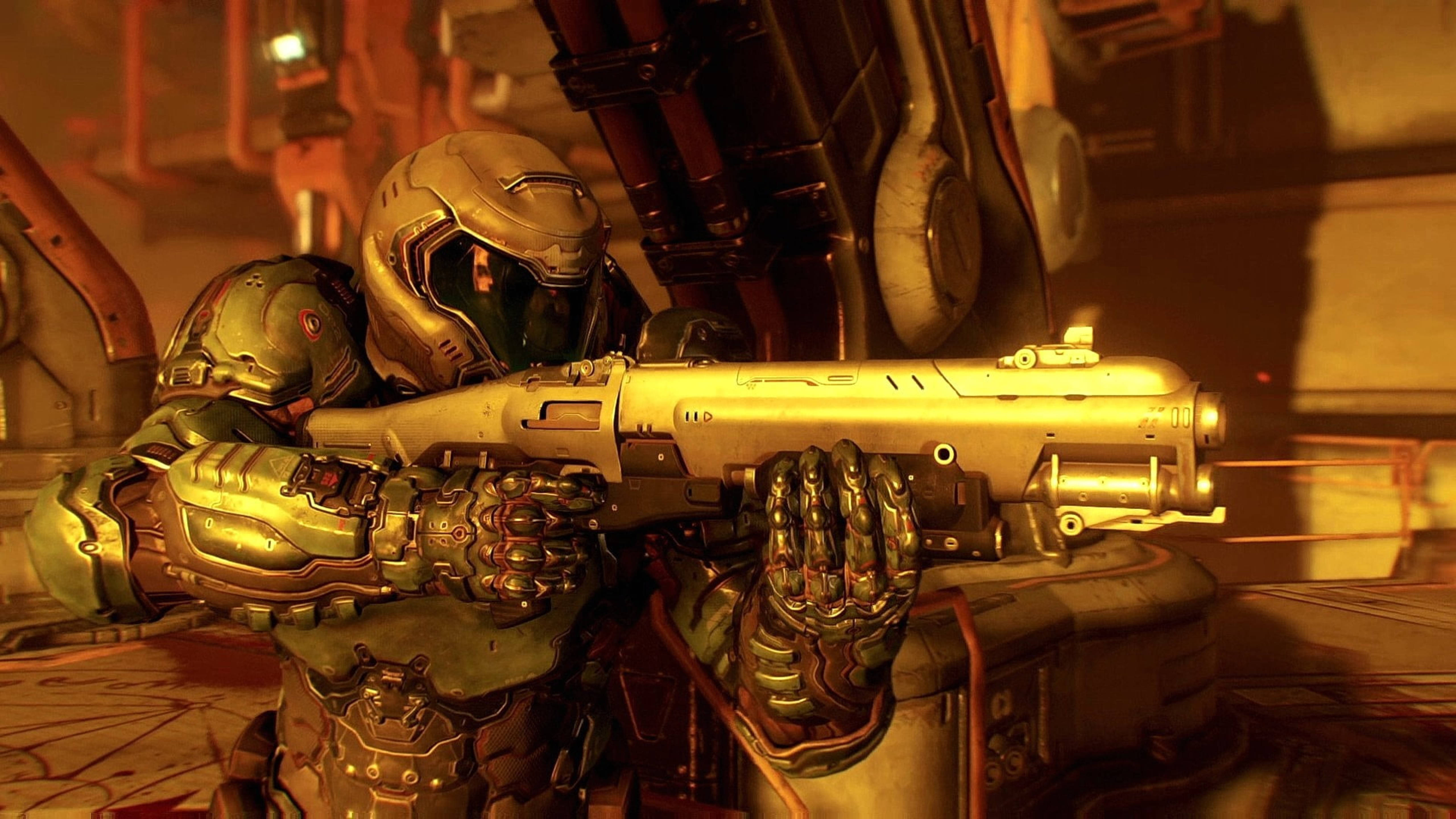 Doomguy 桌布 壁紙 — 一名身穿綠色和金色盔甲的士兵在光線昏暗、帶有橙色照明的工業走廊中瞄準重型武器。