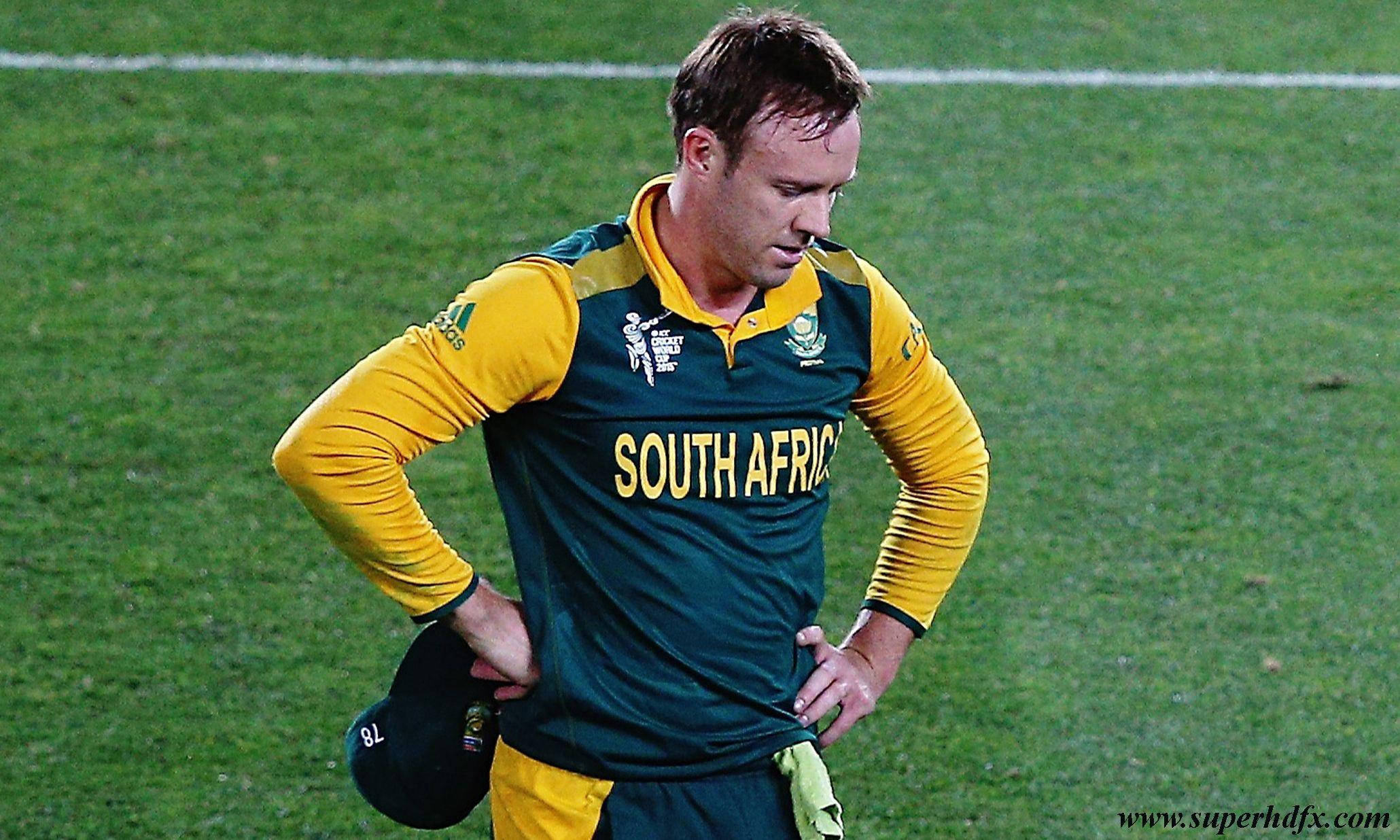 Ab De Villiers 桌布 壁紙 — 一名身穿綠色和黃色球衣的南非板球運動員在球場燈光下雙手叉腰站在草地上，神情沮喪。
