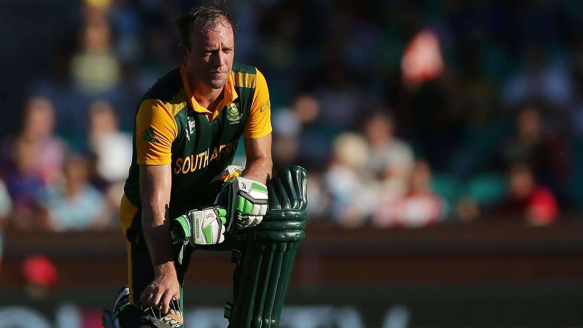 Ab De Villiers 桌布 壁紙 — 一名身穿綠色和黃色球衣的南非板球運動員在比賽中專注地靠在球棒上。