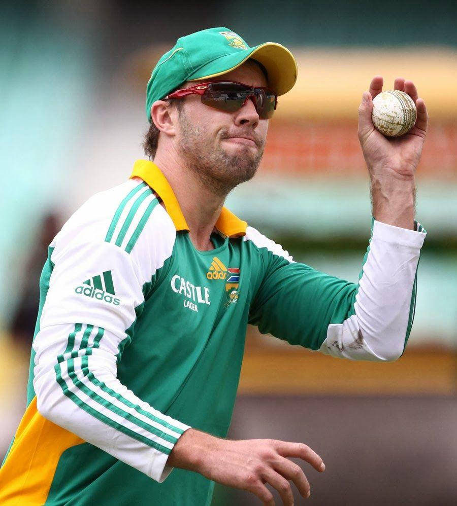 Ab De Villiers 桌布 壁紙 — 一名身穿綠色和黃色球衣的板球運動員在陽光明媚的戶外比賽中，在動作中握住球。