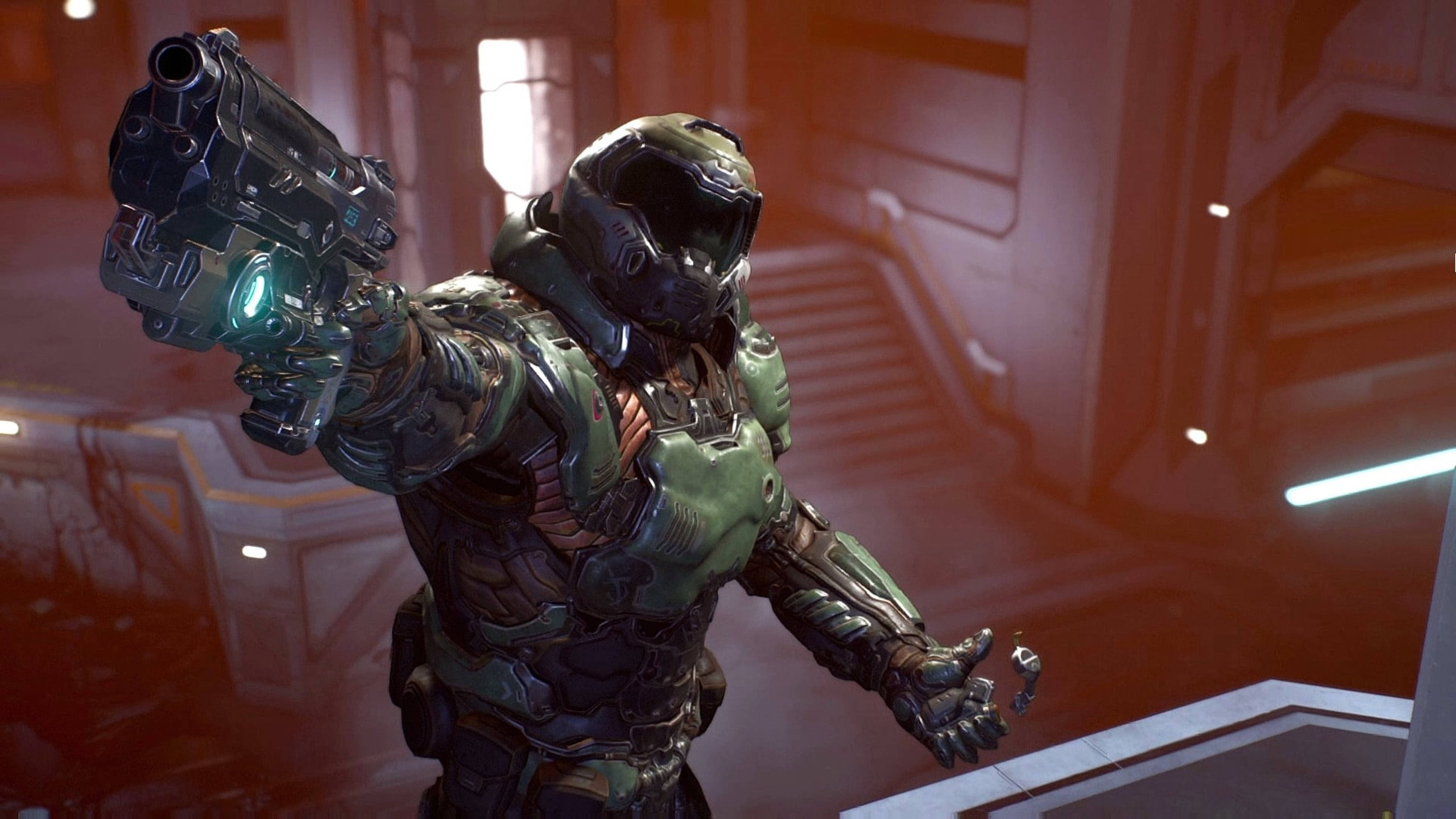 Doomguy 桌布 壁紙 — 一名身穿綠色和黑色裝甲的重裝太空陸戰隊員在昏暗的科幻走廊中瞄準一把發光的未來手槍。