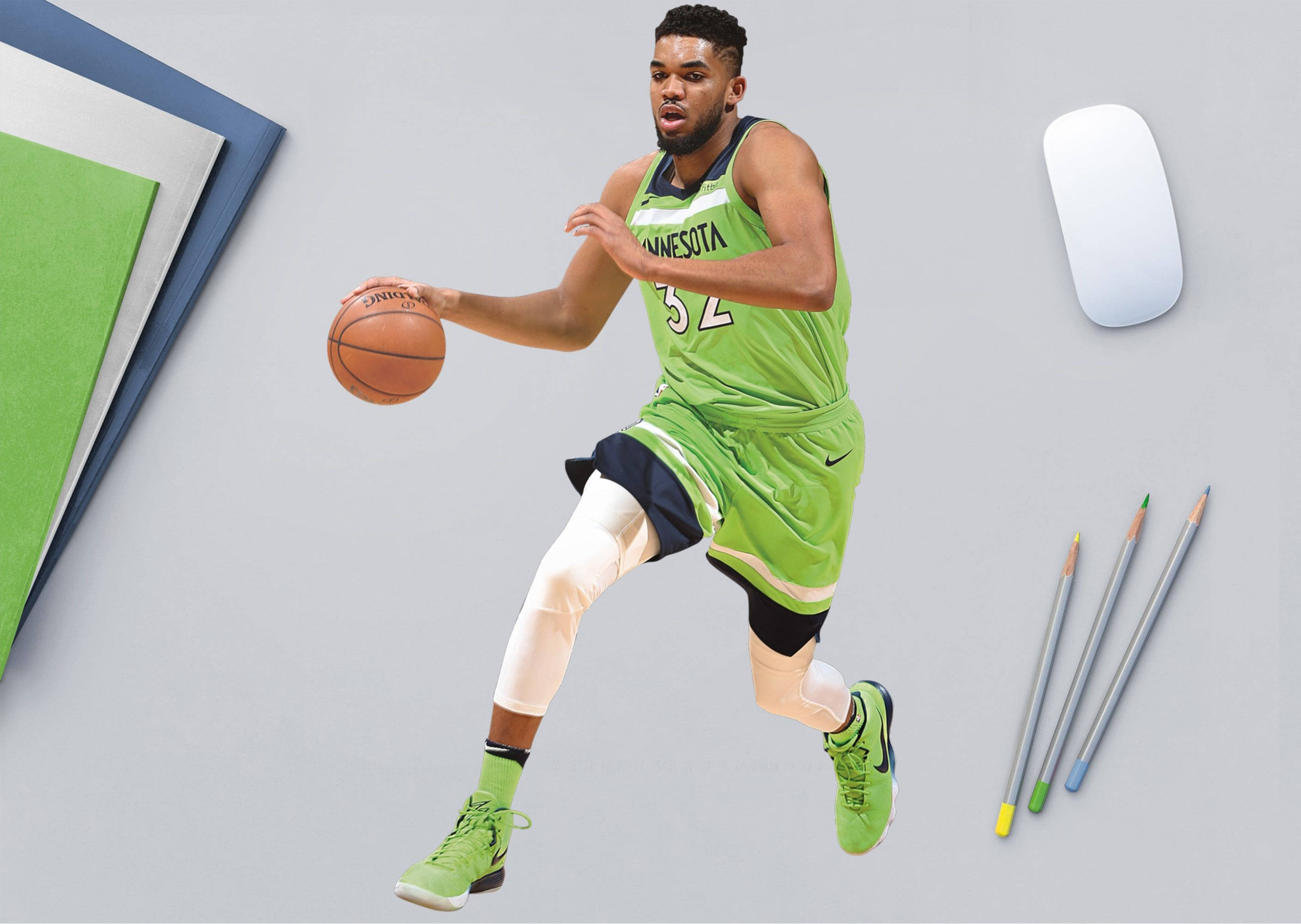 karl-anthony towns 桌布 壁紙 — 一名身穿綠色明尼蘇達球衣的籃球運動員在灰色背景上，被鉛筆和電腦滑鼠包圍，在半空中運球。
