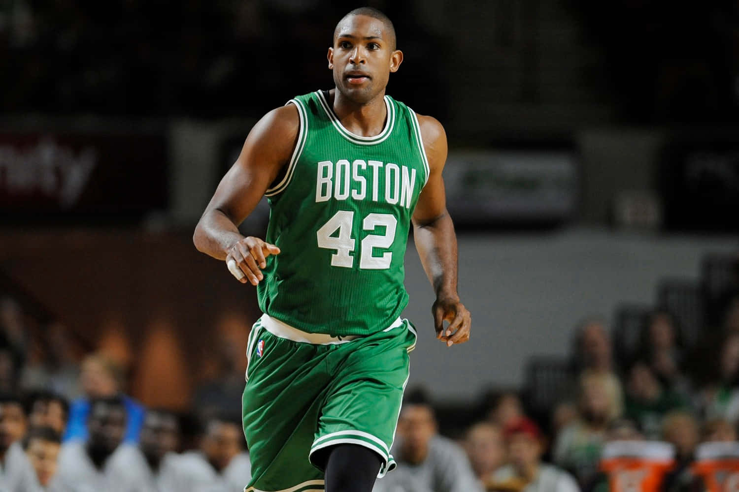Al Horford 桌布 壁紙 — 一名身穿綠色波士頓塞爾提克球衣、號碼42的籃球運動員在場館燈光下於比賽中動態奔跑。