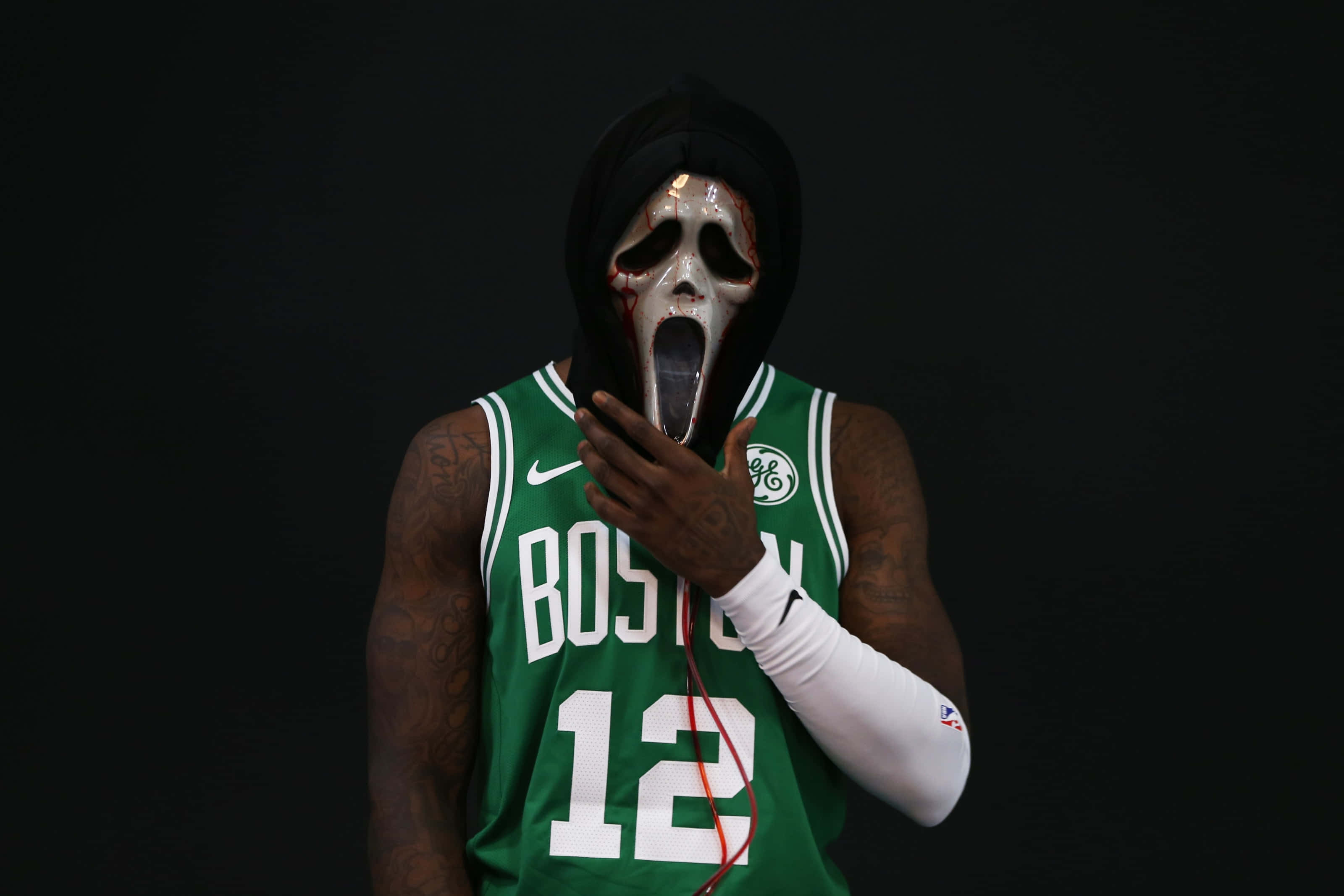 NBA 桌布 壁紙 — 一名身穿綠色波士頓球衣的籃球運動員，在黑色背景前戴著帶有紅色繩子的白色Ghostface面具。