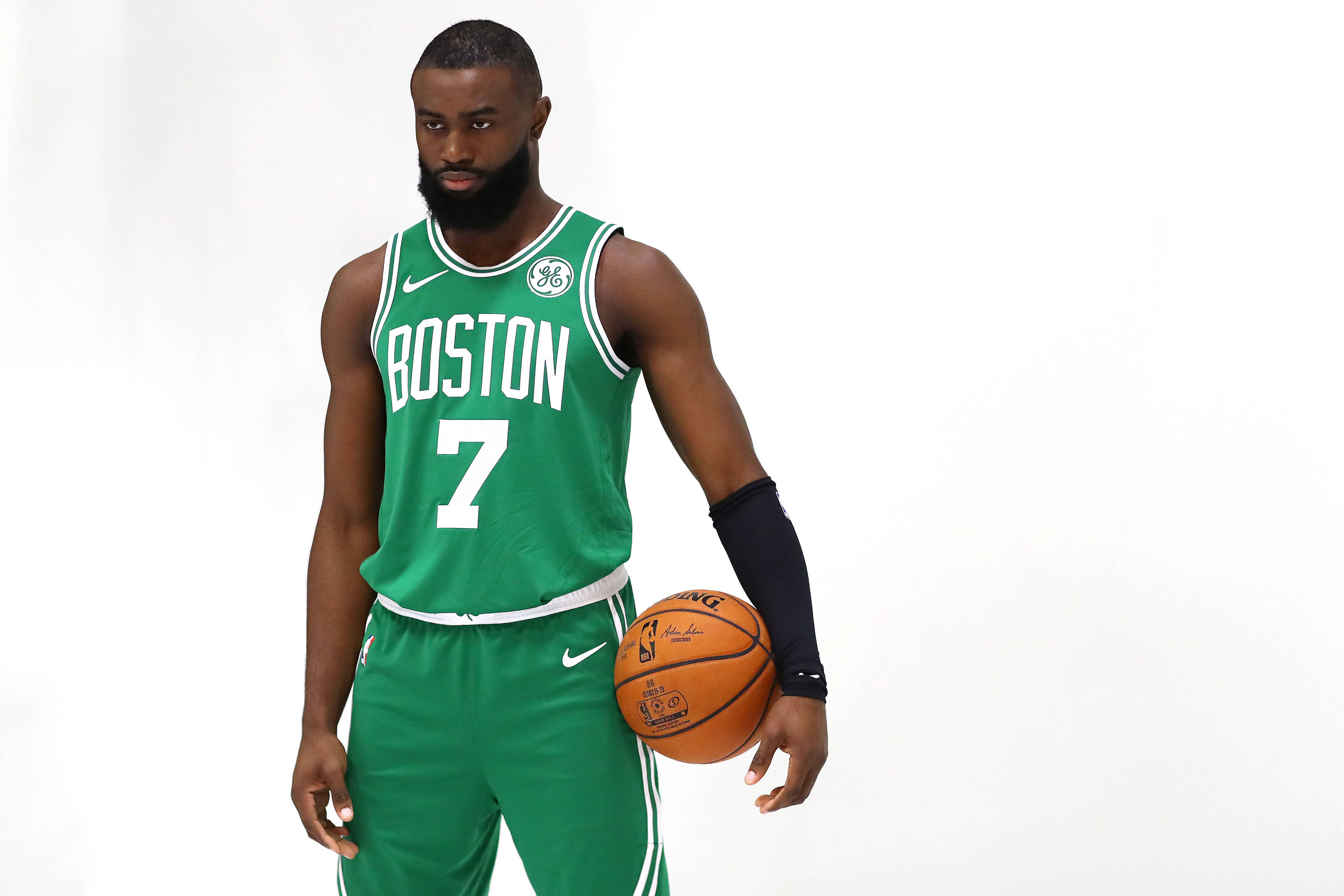 Jaylen Brown 桌布 壁紙 — 一名身穿綠色波士頓球衣的籃球運動員在純白色背景前拿著一個球。
