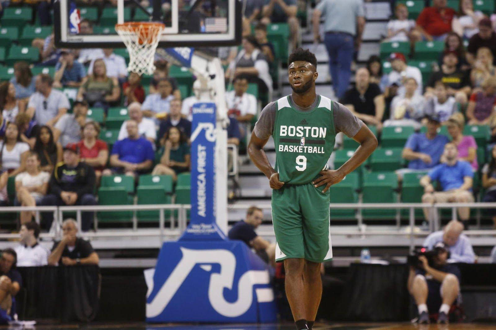 Jaylen Brown 桌布 壁紙 — 一名身穿綠色波士頓籃球球衣的籃球運動員自信地站在球場上，雙手叉腰，觀眾從綠色座位觀看。
