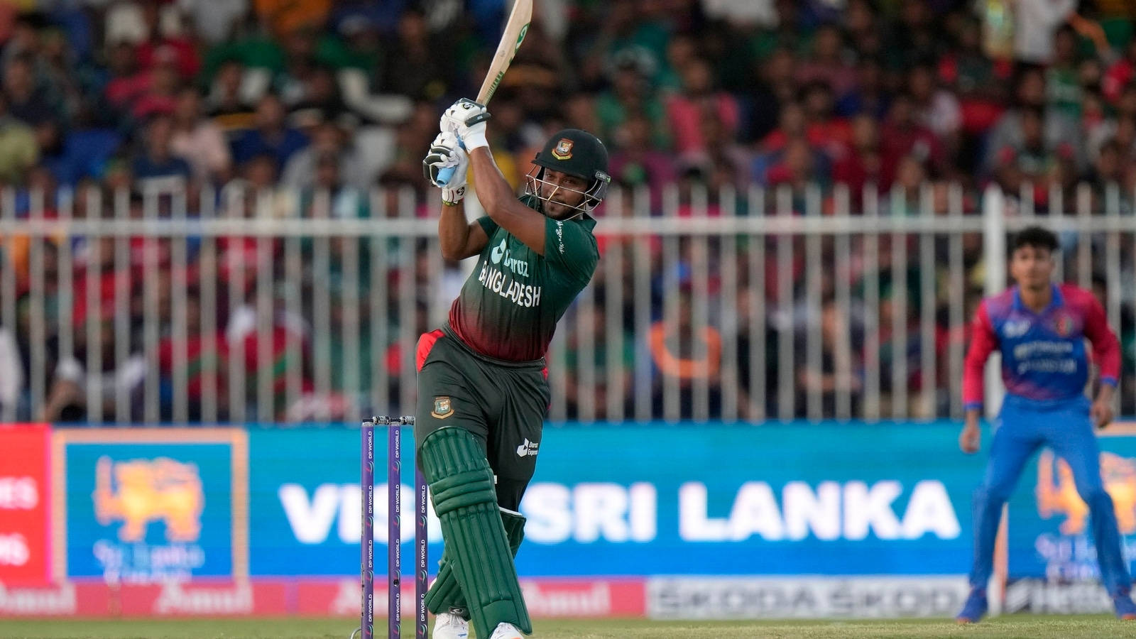 Shakib Al Hasan 桌布 壁紙 — 一名身穿綠色球衣的孟加拉板球運動員在比賽中強力揮棒，背景有觀眾。