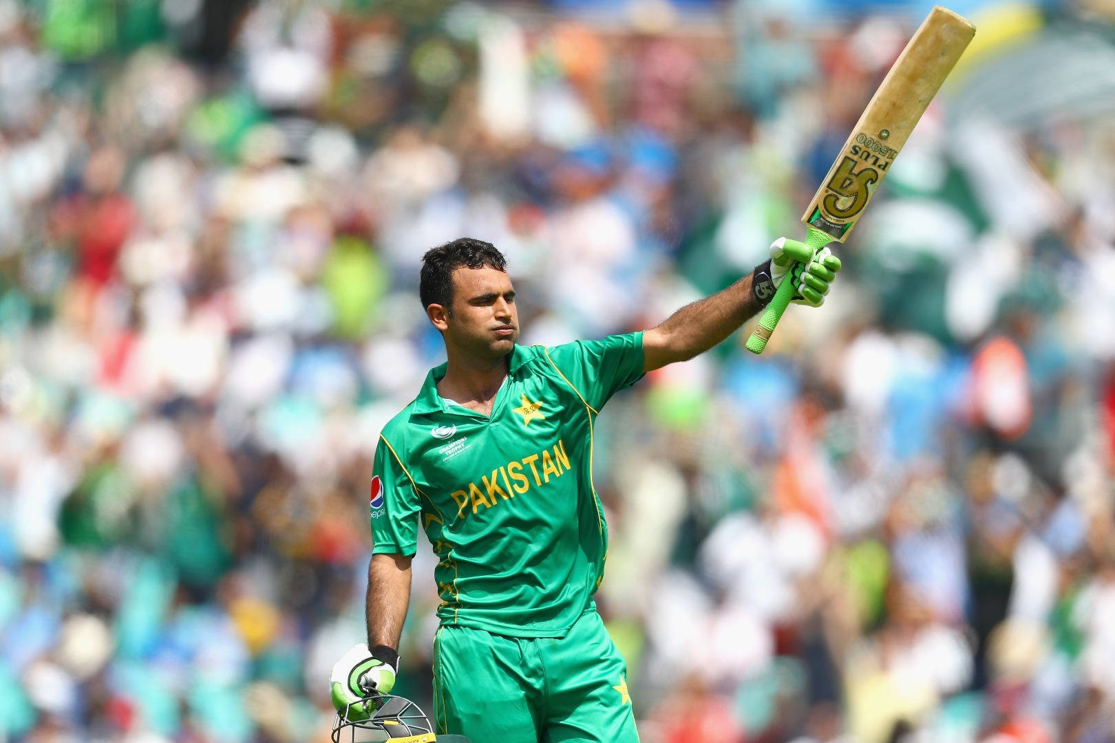 Fakhar Zaman 桌布 壁紙 — 一名身穿綠色球衣的巴基斯坦板球運動員在明亮的日光下，向歡呼的人群勝利地舉起球棒。