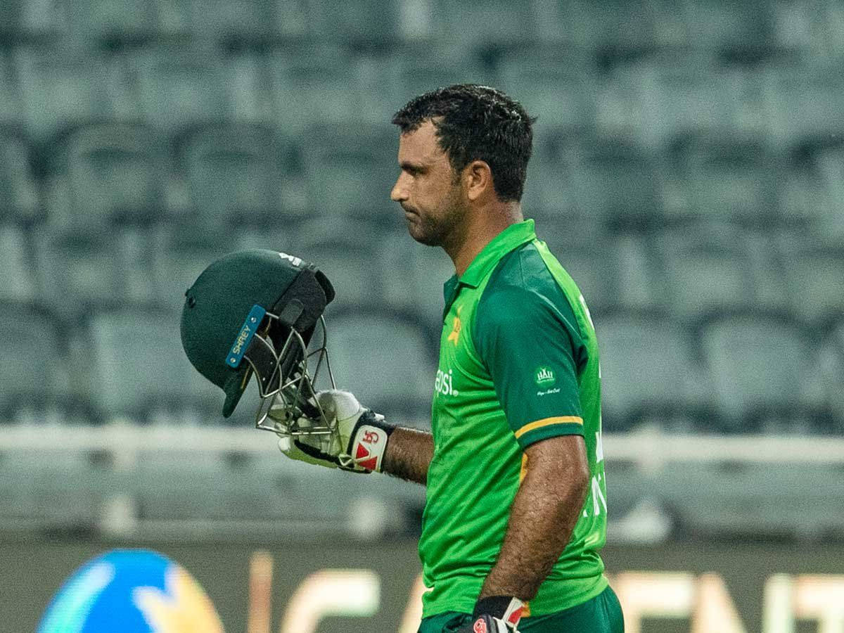 Fakhar Zaman 桌布 壁紙 — 一名身穿綠色球衣的巴基斯坦板球運動員在空無一人的球場上失望地走著，手裡拿著頭盔。