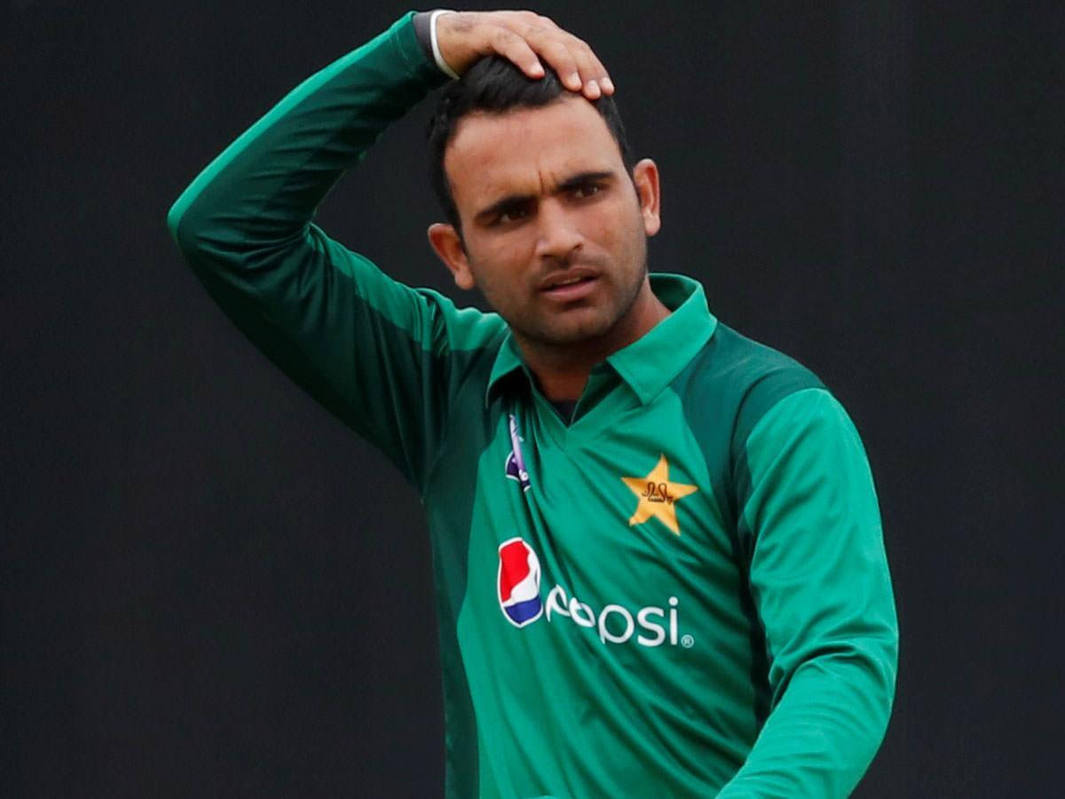 Fakhar Zaman 桌布 壁紙 — 一名身穿綠色球衣的巴基斯坦板球運動員在深色背景下，表情沮喪地用手撥弄頭髮。