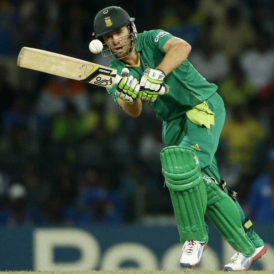 Ab De Villiers 桌布 壁紙 — 一名身穿綠色球衣的板球擊球手在夜間比賽中，在球場燈光下揮動球棒擊打白色球。