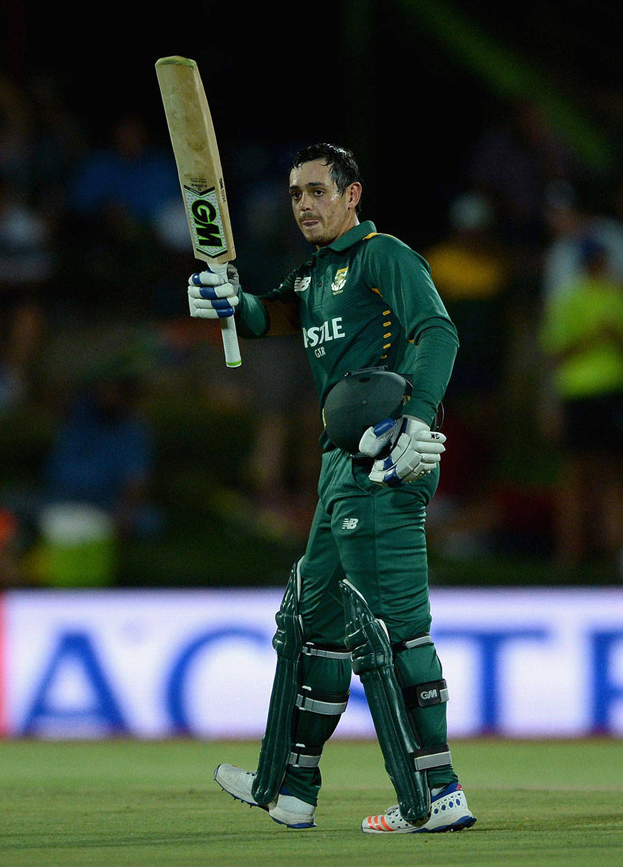 quinton de kock 桌布 壁紙 — 一名身穿綠色球衣的板球運動員在球場燈光下，於明亮的場地上高舉球棒。