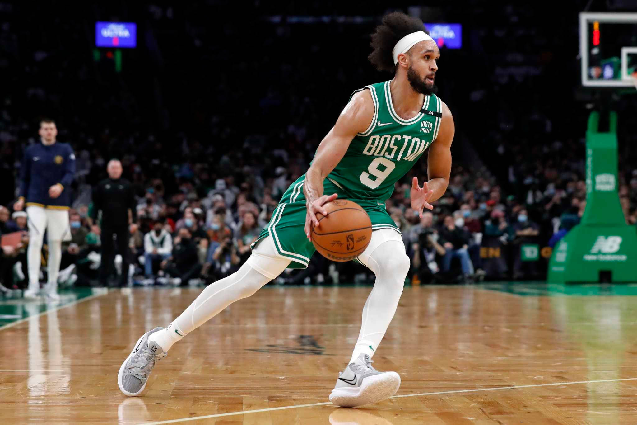 NBA 桌布 壁紙 — 一名身穿綠色球衣的波士頓塞爾提克球員在座無虛席的場館比賽中，專注地運球。