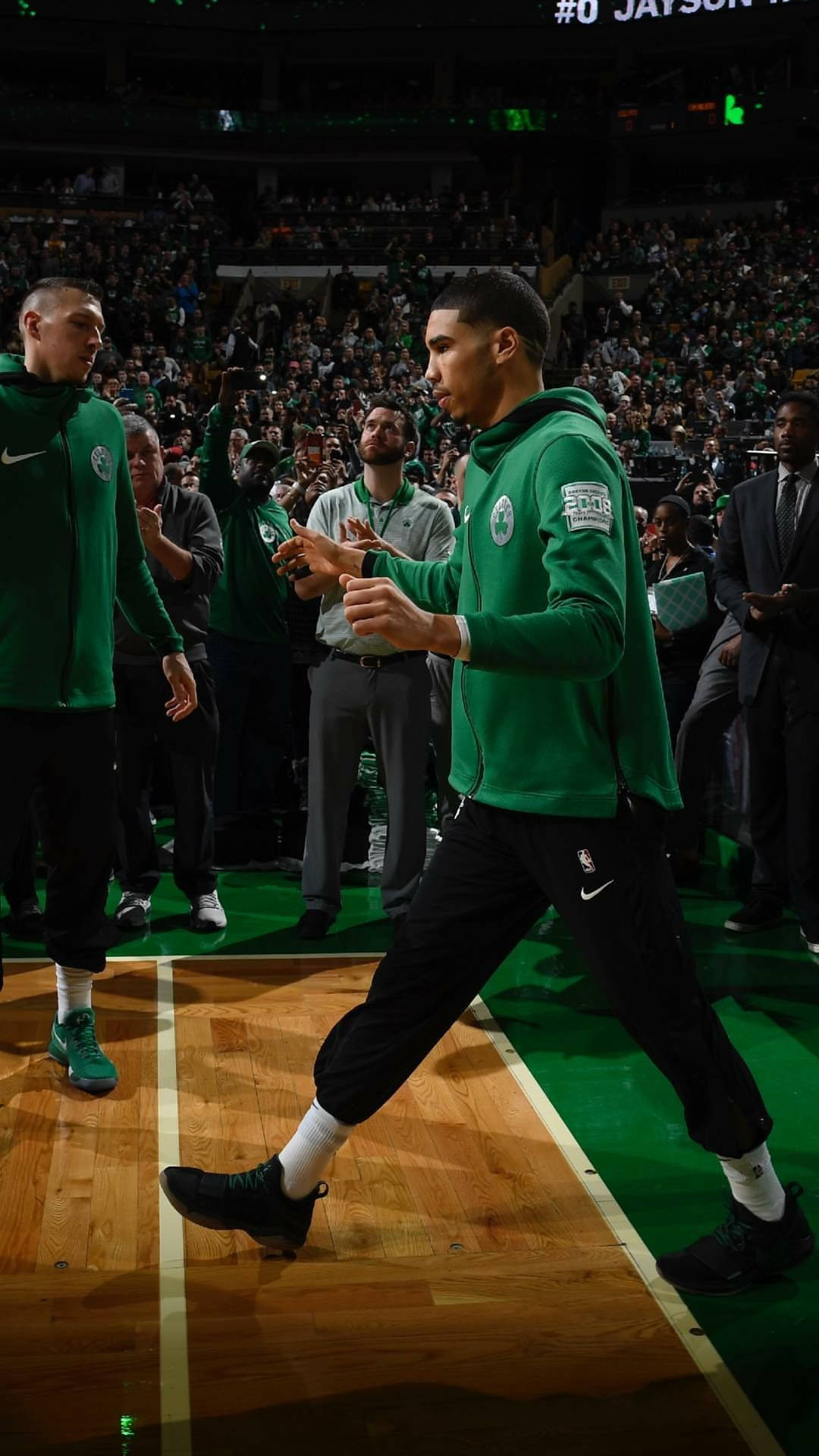 Jayson 桌布 壁紙 — 一名身穿綠色球衣的籃球運動員自信地走過硬木球場，背景是球迷的歡呼聲。