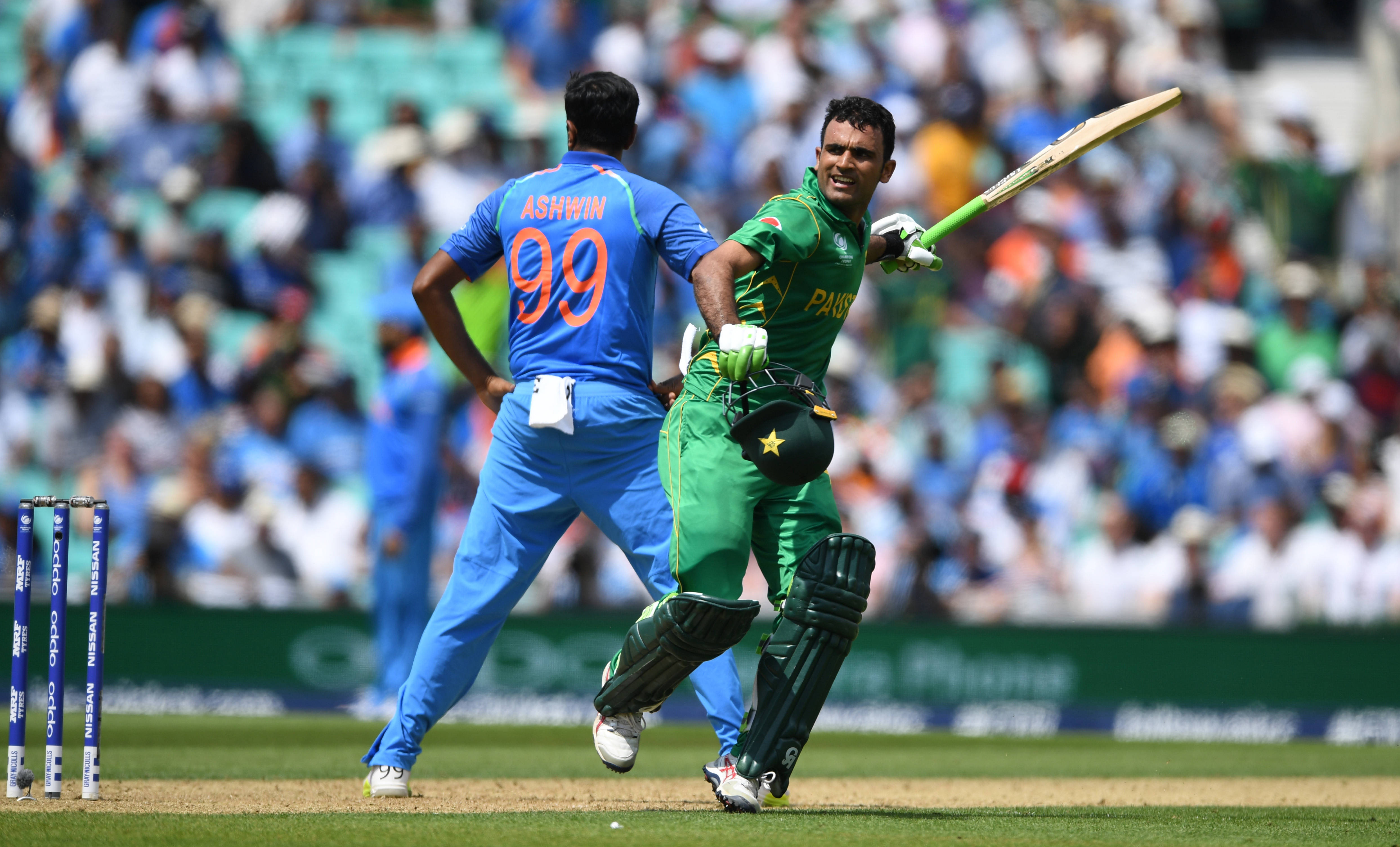 Fakhar Zaman 桌布 壁紙 — 一名身穿綠色的巴基斯坦板球運動員慶祝強力擊球，而一名身穿藍色的印度投球手從後面觀看。